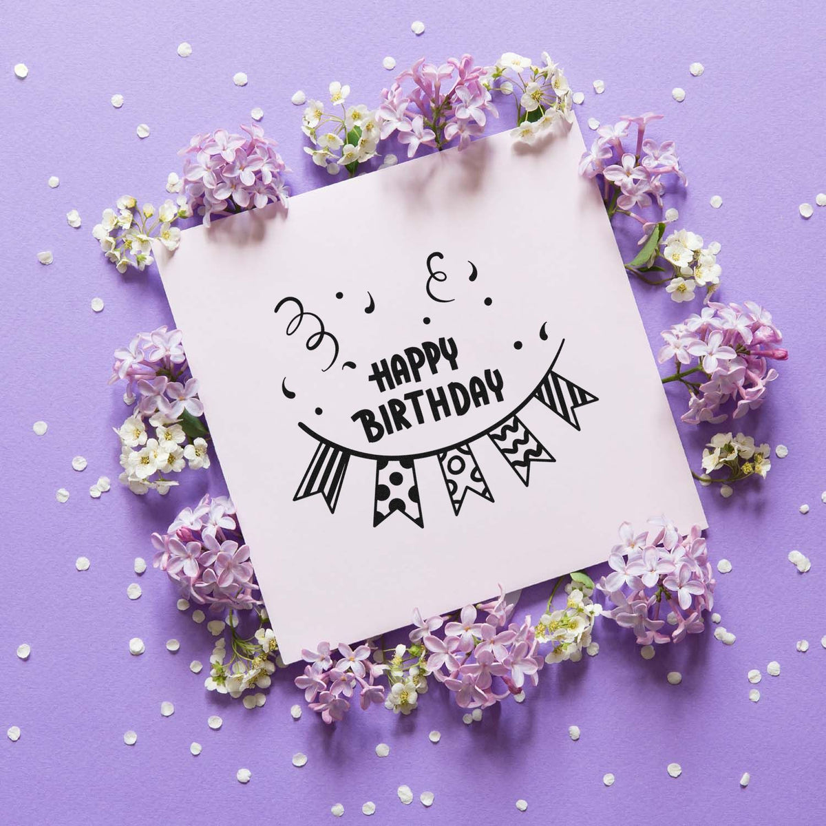 Happy Birthday stamp and seal design on a white card, framed by lilac and white flowers on a lavender background.