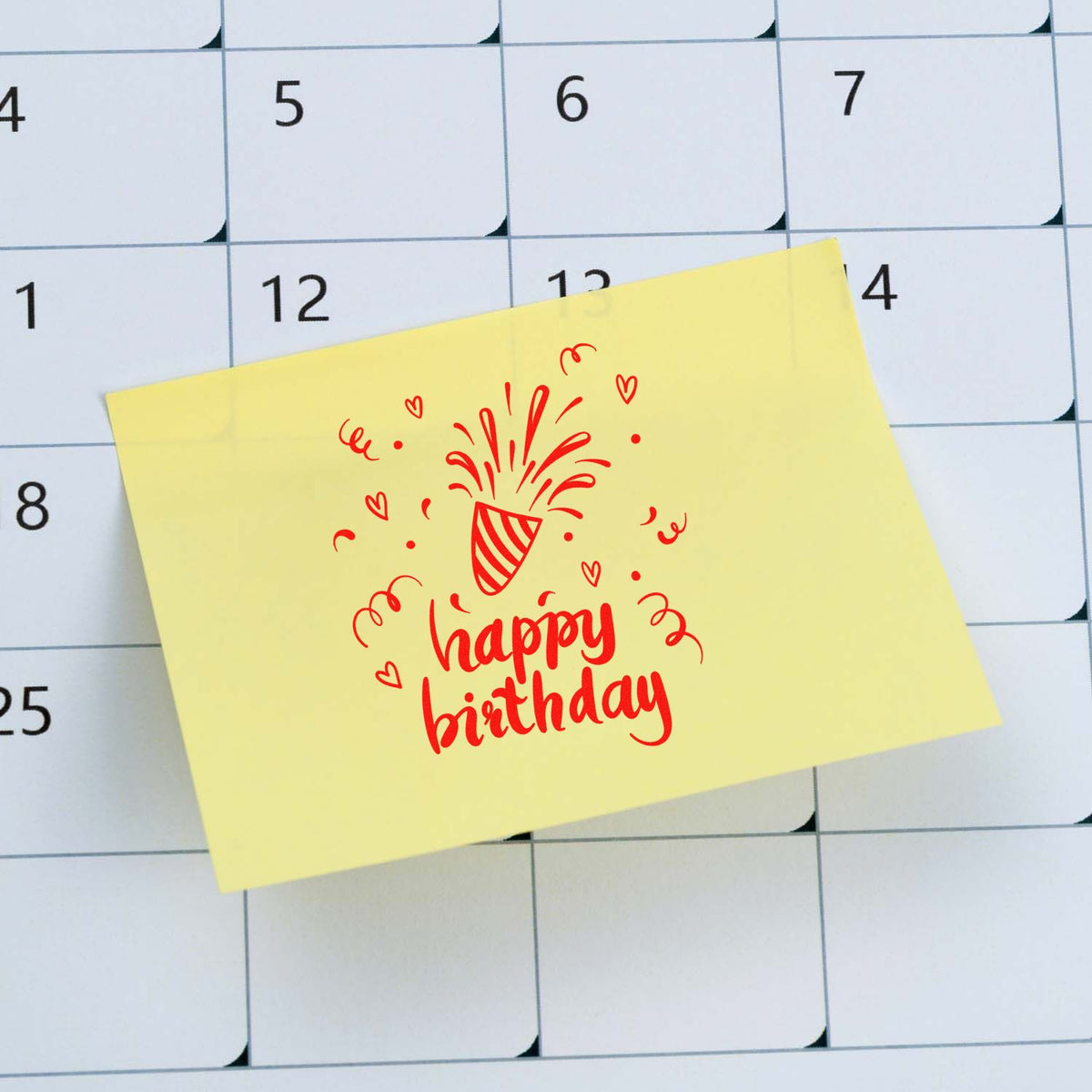 Yellow sticky note featuring a red happy birthday stamp seal and confetti on a white calendar grid.