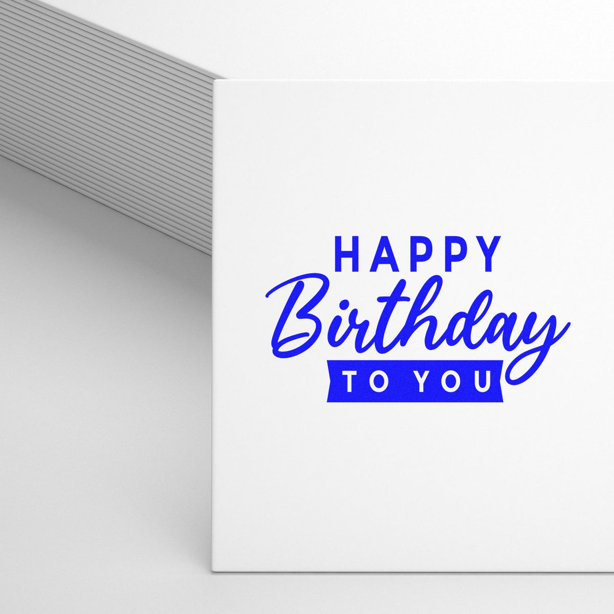 Blue Happy Birthday to You stamp and seal on white card beside a gray envelope.