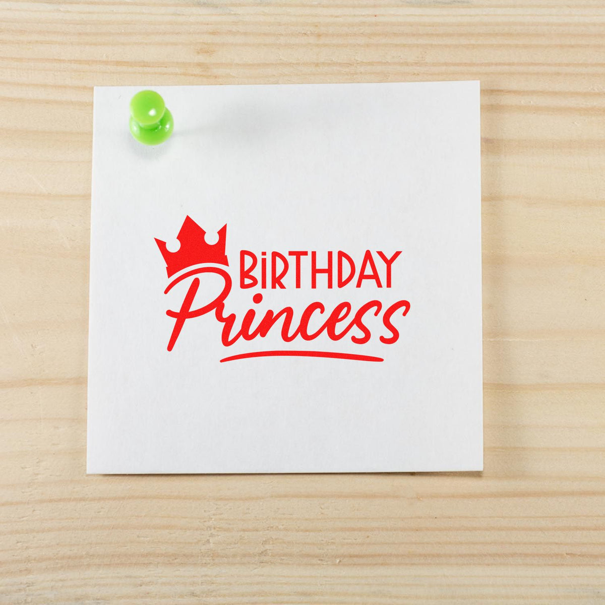 Red Birthday Princess stamp and seal with crown on white card, pinned with green pushpin on light wood background.