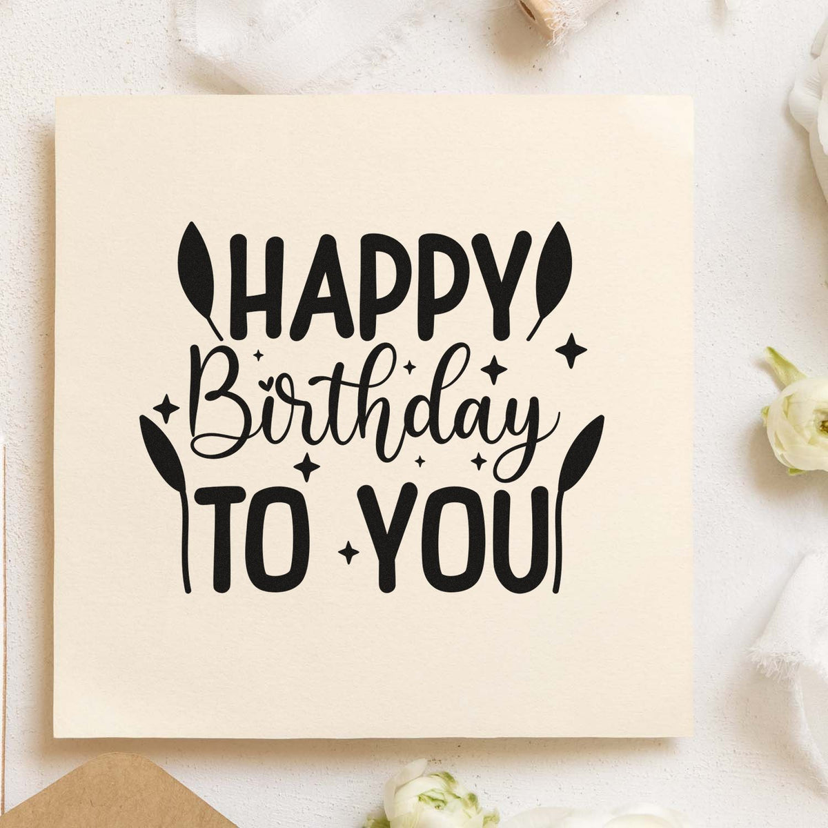 Black Happy Birthday to You rubber stamp design on cream paper, with playful leaves, stars, and a seal-style layout.