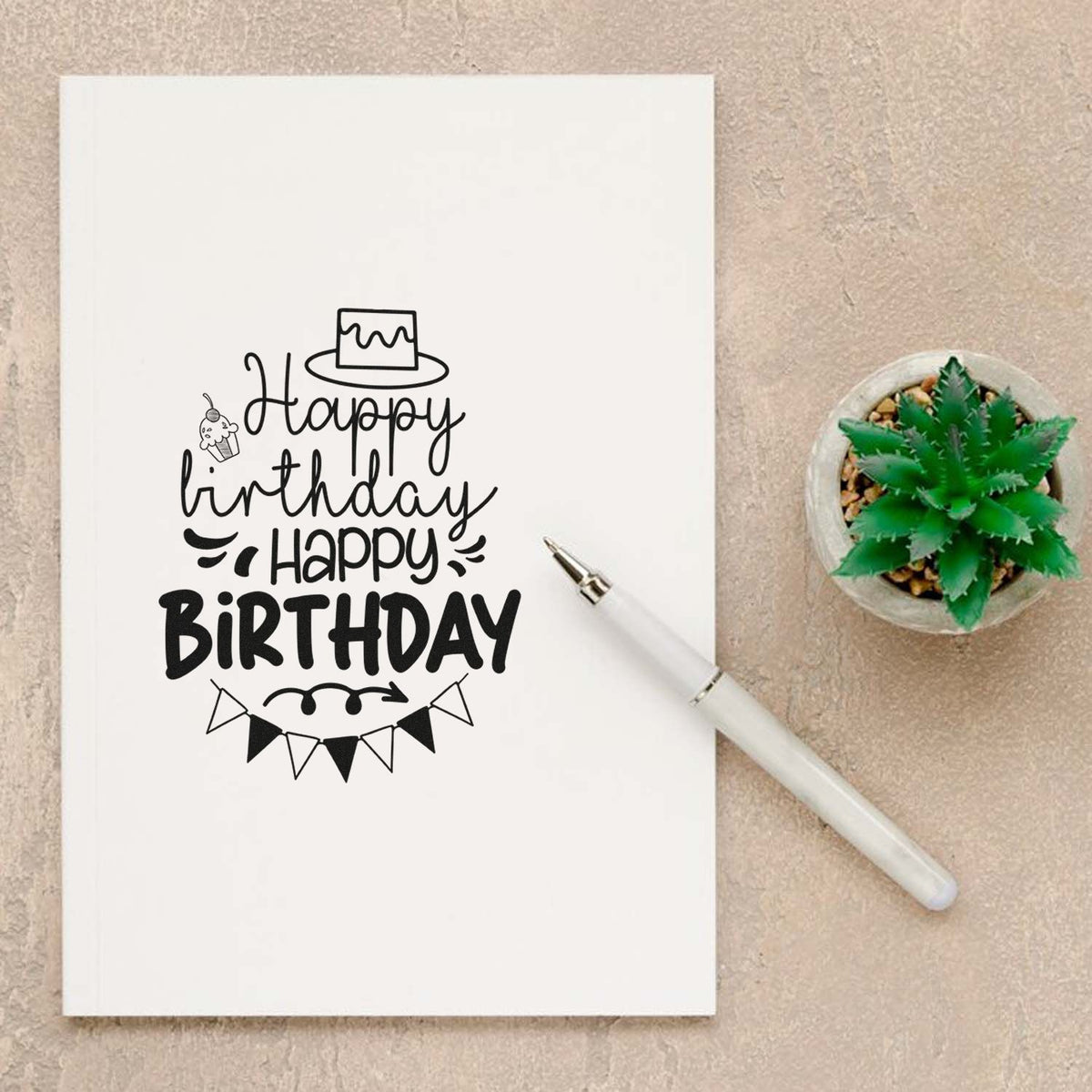 Black Happy Birthday stamp and seal design on white paper with cake, bunting, cupcake icon, and white embossing pen.