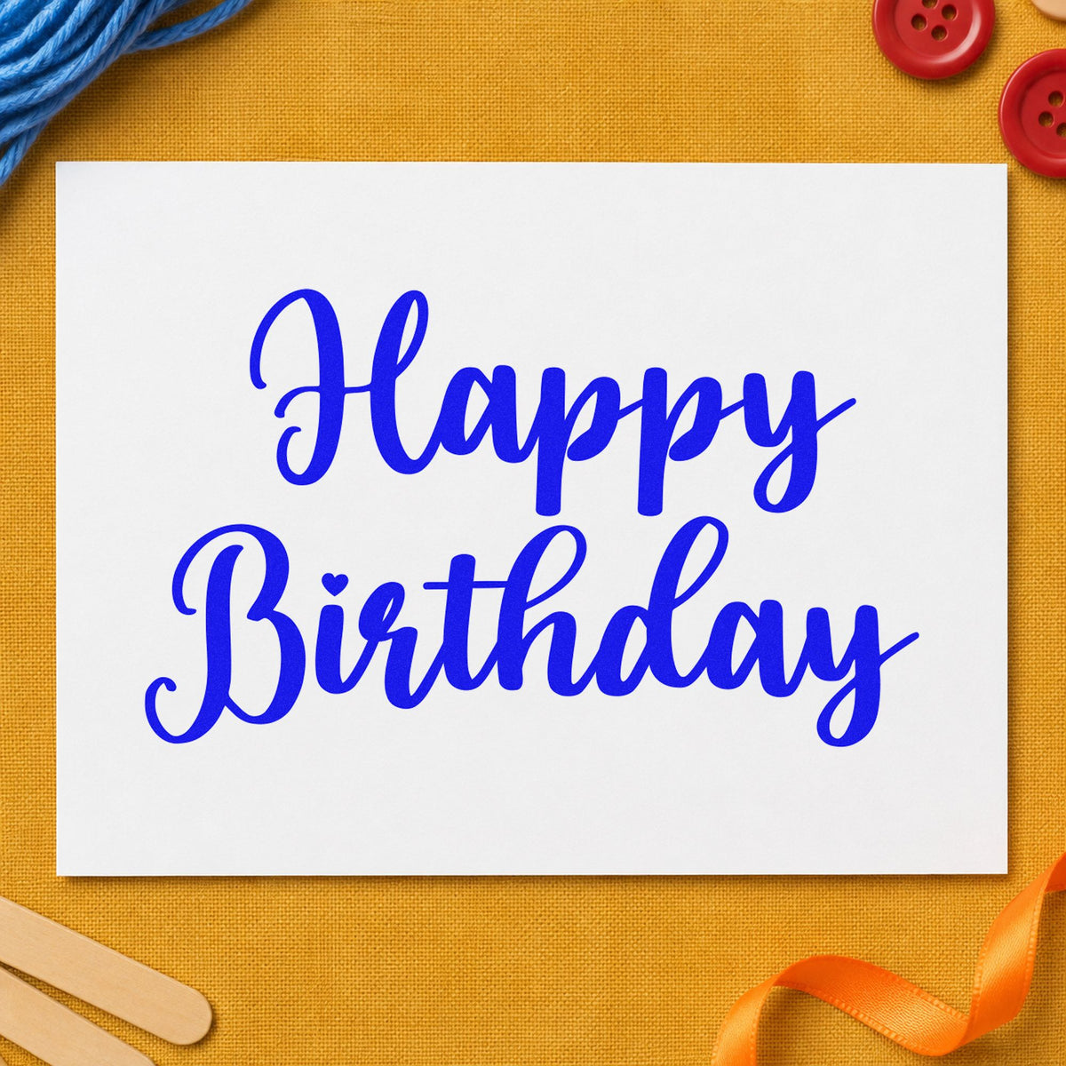 Happy Birthday Bold Script craft stamp in blue ink on cardstock, an easy option for work apron printing.