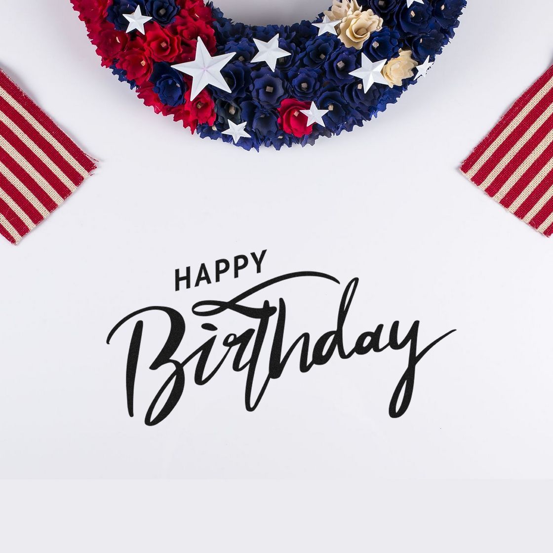 Happy Birthday stamp and seal on white, with black script, red, white and blue floral wreath, and striped ribbon accents.
