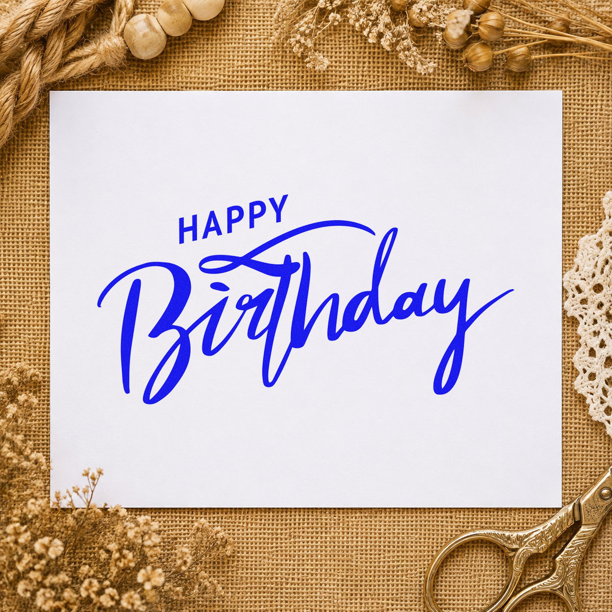 Happy Birthday Brush Flourish craft stamp in blue ink on cardstock, an easy option for kit bag printing.