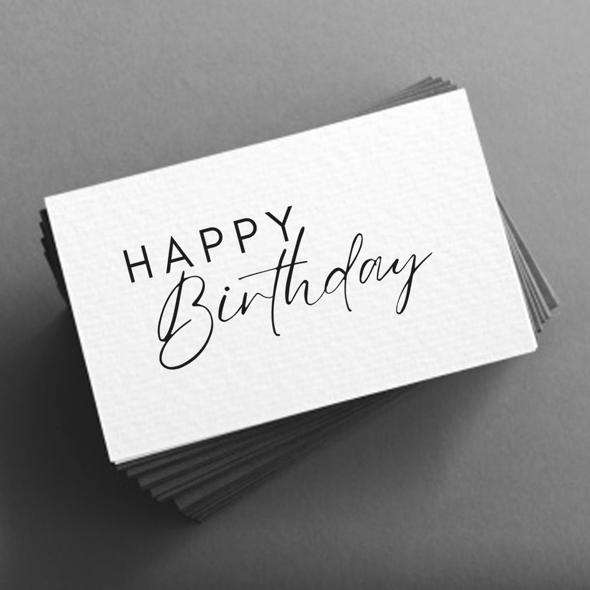 Stacked white birthday stamp and seal cards with black Happy Birthday lettering on a gray background.