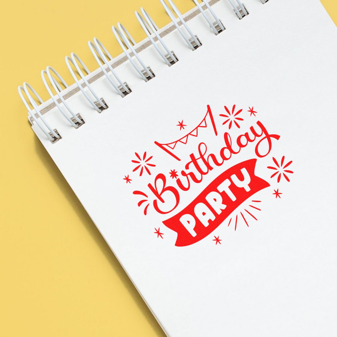 Red birthday party stamp seal on a white spiral notebook with yellow background