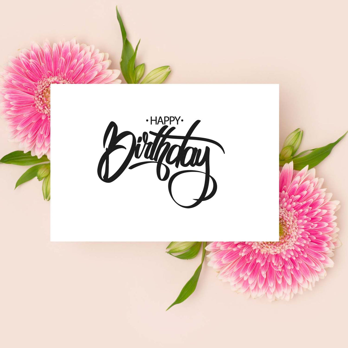Happy Birthday stamp and seal in black script on a white card, framed by pink gerbera flowers and green leaves on a beige background.