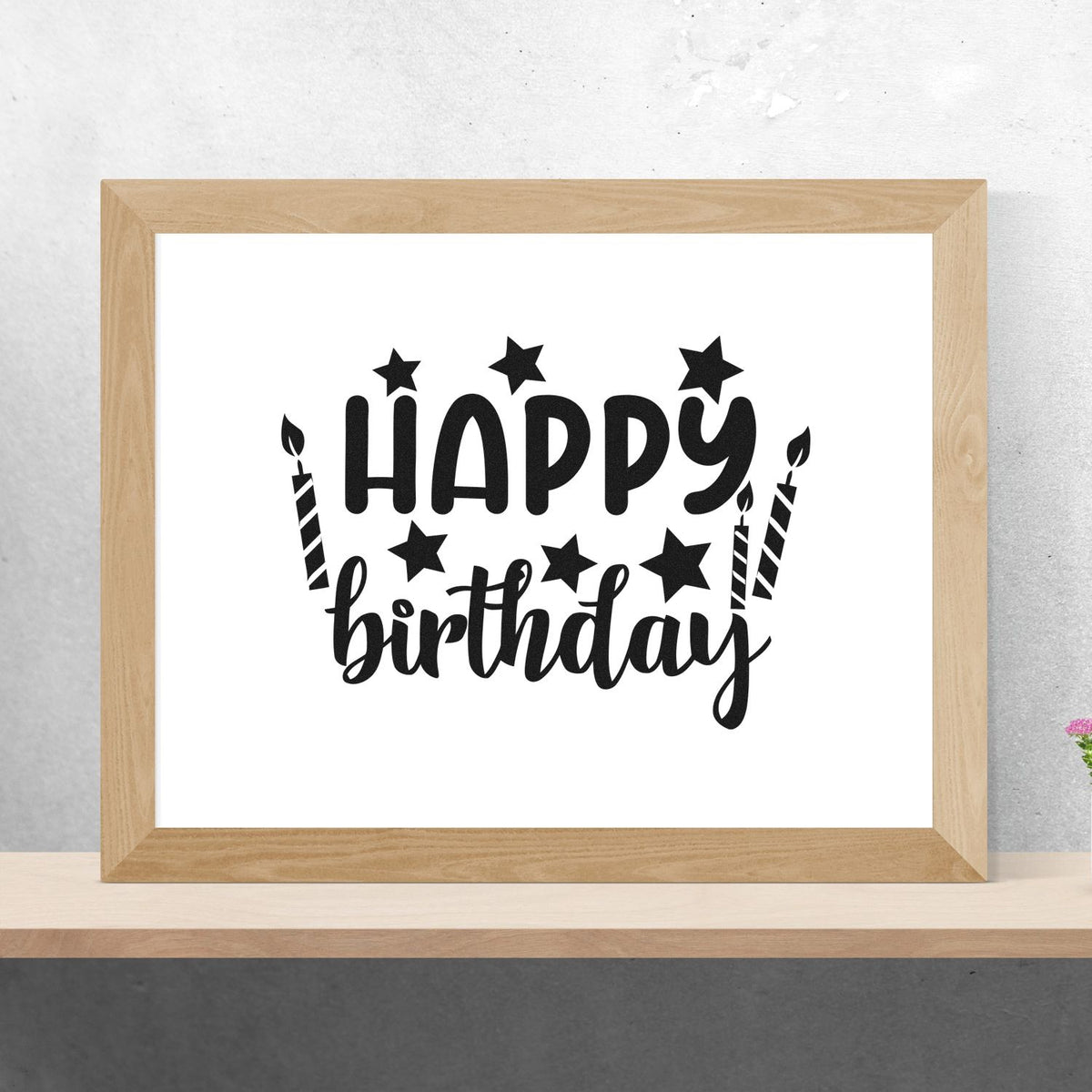 Black Happy Birthday stamp/seal design with stars and candles in a light wood frame