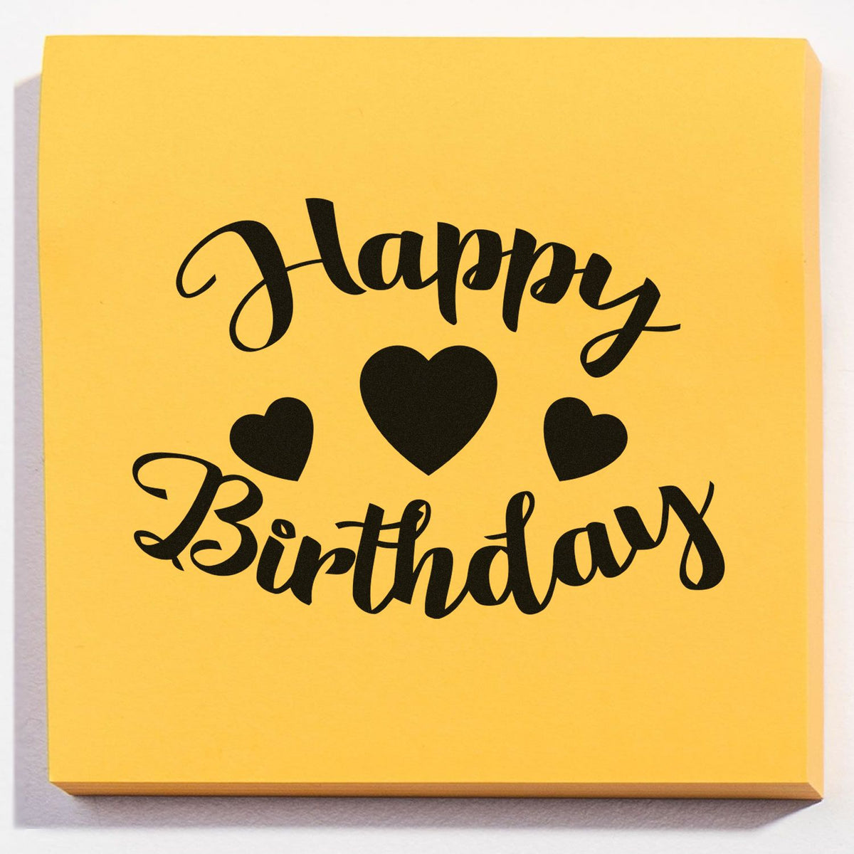 Yellow Happy Birthday stamp seal with black script lettering and three heart icons