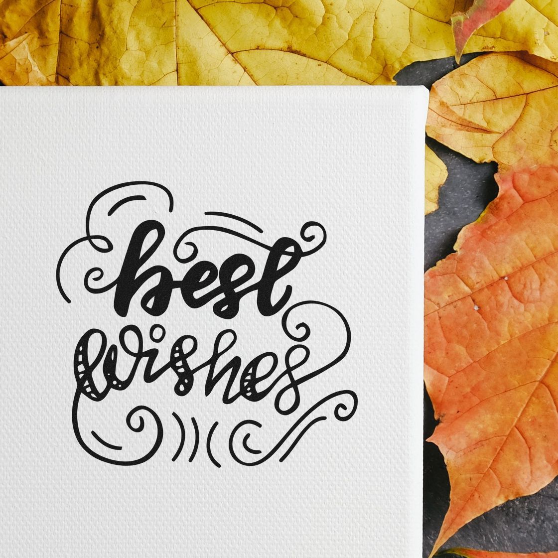 Black best wishes stamp and seal on white textured paper, framed by orange and yellow autumn leaves.