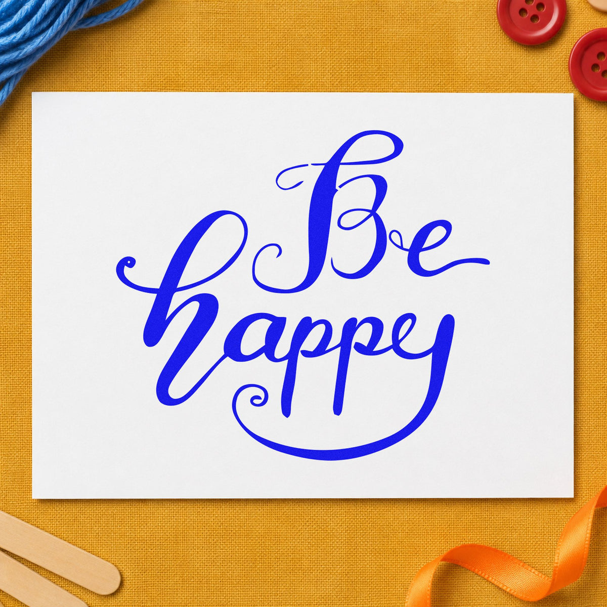 Be Happy Flowing Script craft stamp in blue ink on cardstock, an easy option for robe panel printing.
