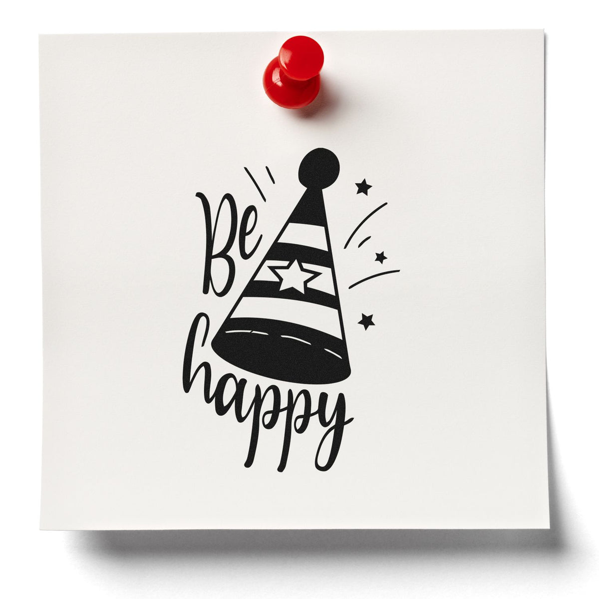 Black Be happy party-hat rubber stamp on white paper, with a red seal/push pin and star accents.
