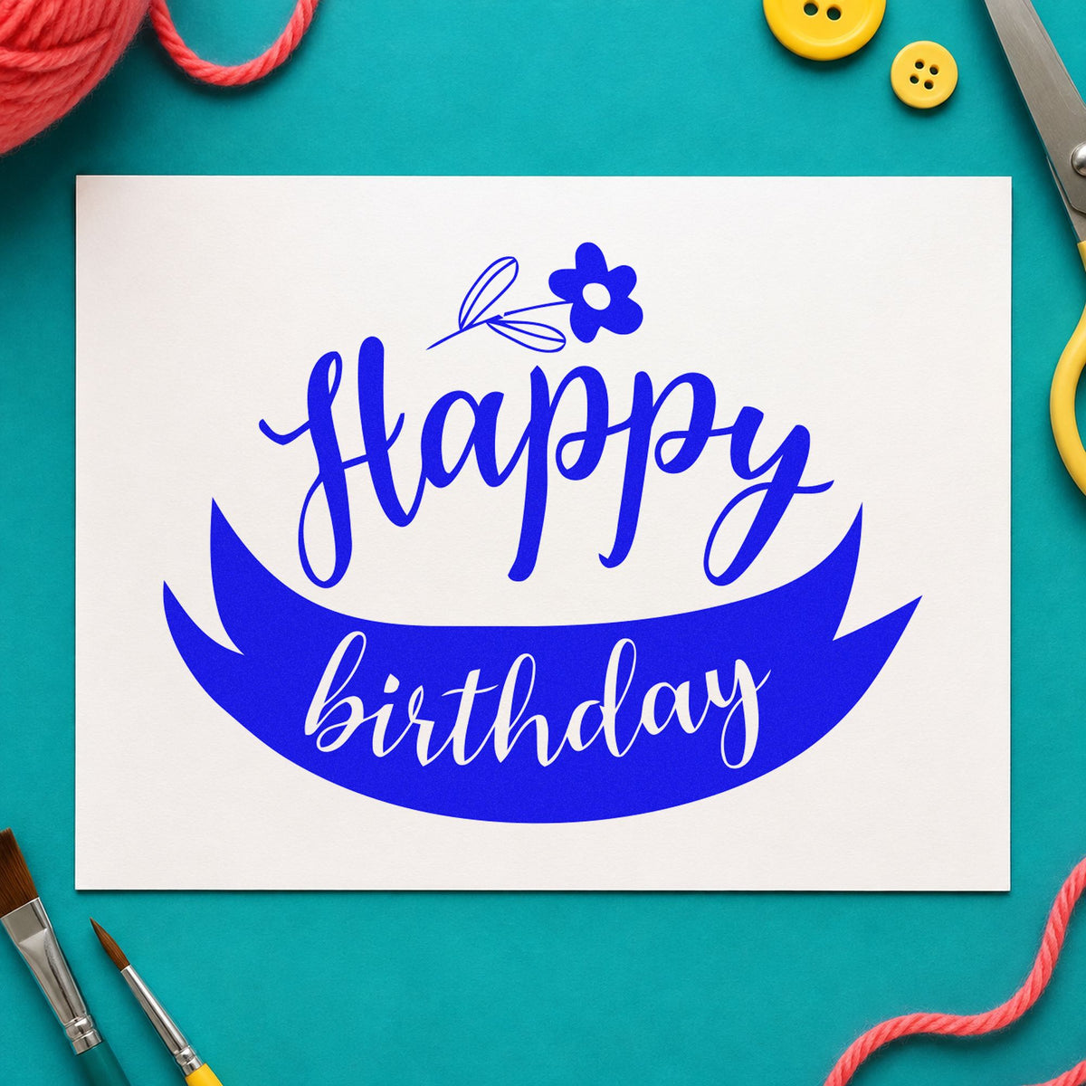 Happy Birthday Flower Ribbon craft stamp in blue ink on cardstock, an easy option for garden apron printing.