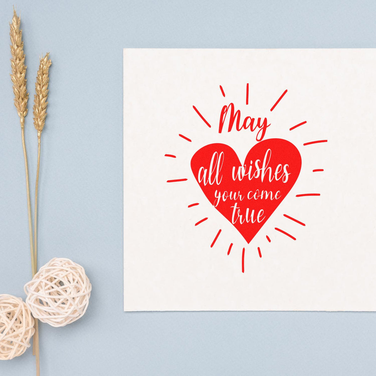 Red heart wax seal with May all wishes come true on white card, on pale blue background with gold wheat stems.