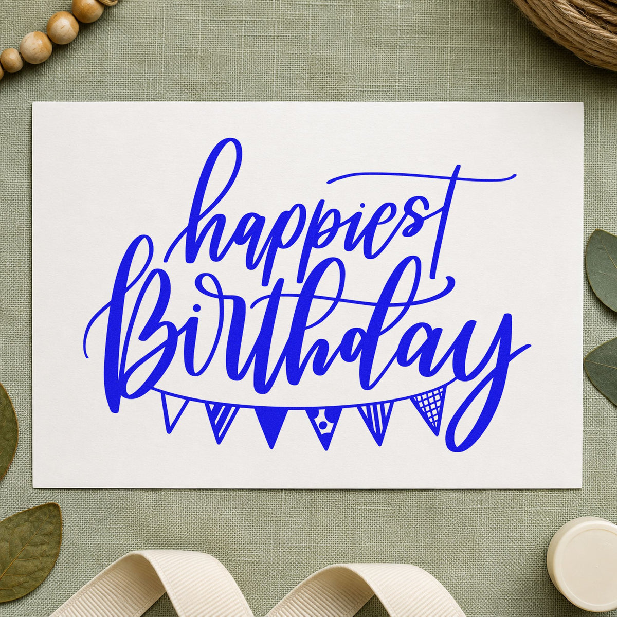 Happiest Birthday Pennant Bunting craft stamp imprinted in blue ink on paper, a design suited to framed stall corner.