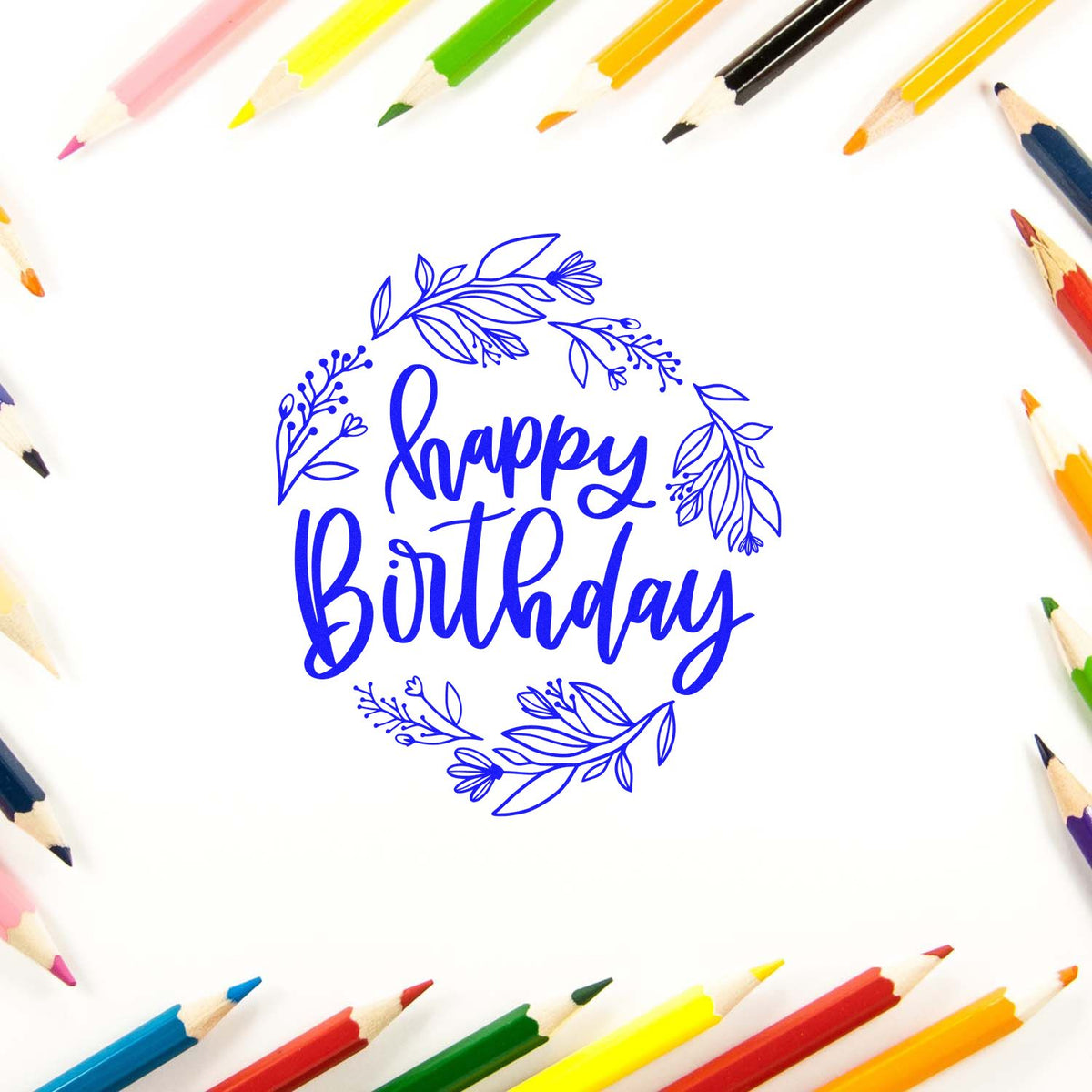 Blue happy Birthday stamp and seal with floral wreath, framed by colorful pencils on a white background.