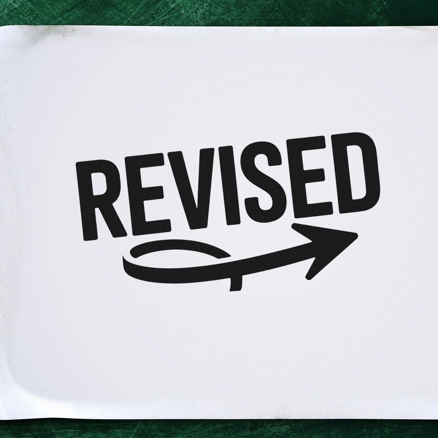 Black REVISED stamp with arrow seal on white paper, set against a dark green background.