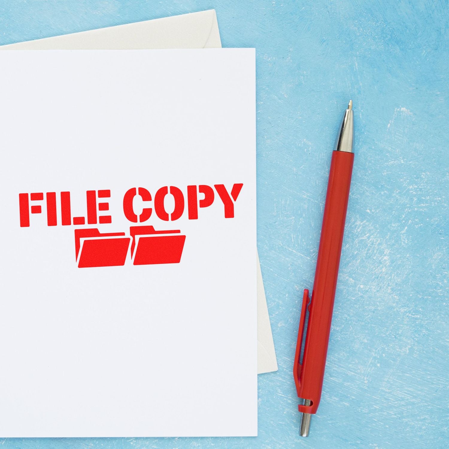 Red FILE COPY rubber stamp on white paper beside a red pen on a light blue background