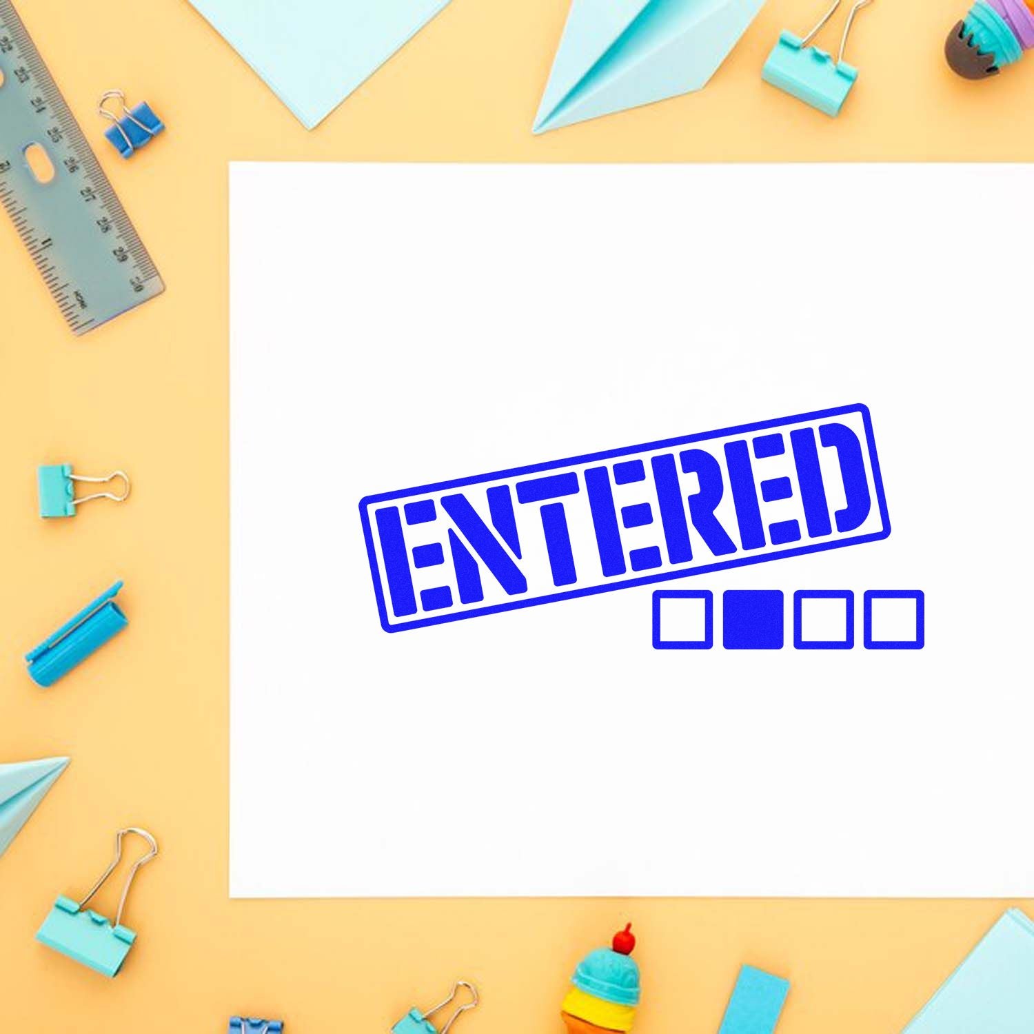 Blue ENTERED stamp on white paper, with pastel binder clips, ruler, and folded paper seal accents on a yellow background.