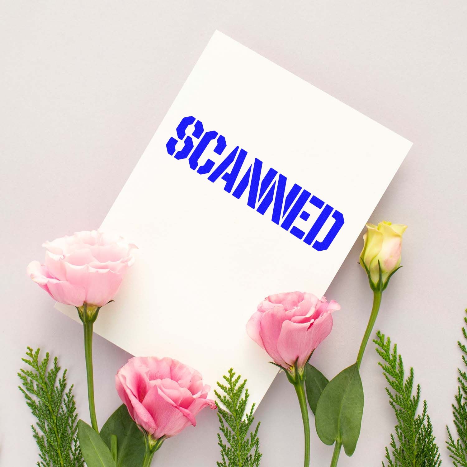 White card with bold blue SCANNED stamp and seal, surrounded by pink flowers and greenery on a soft gray background.