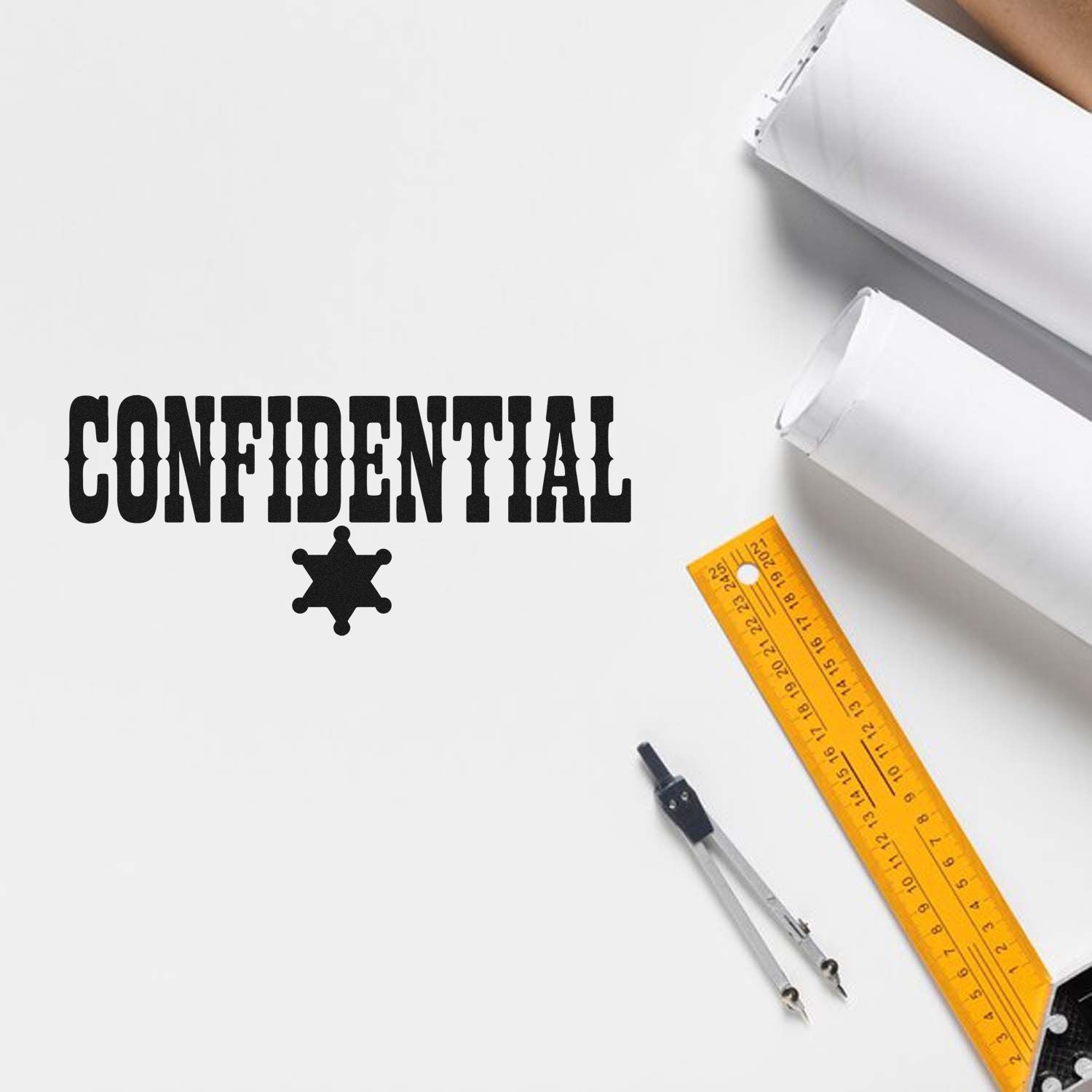 Black CONFIDENTIAL stamp and seal with star icon on white paper, beside white sheets, yellow ruler, and metal compass.