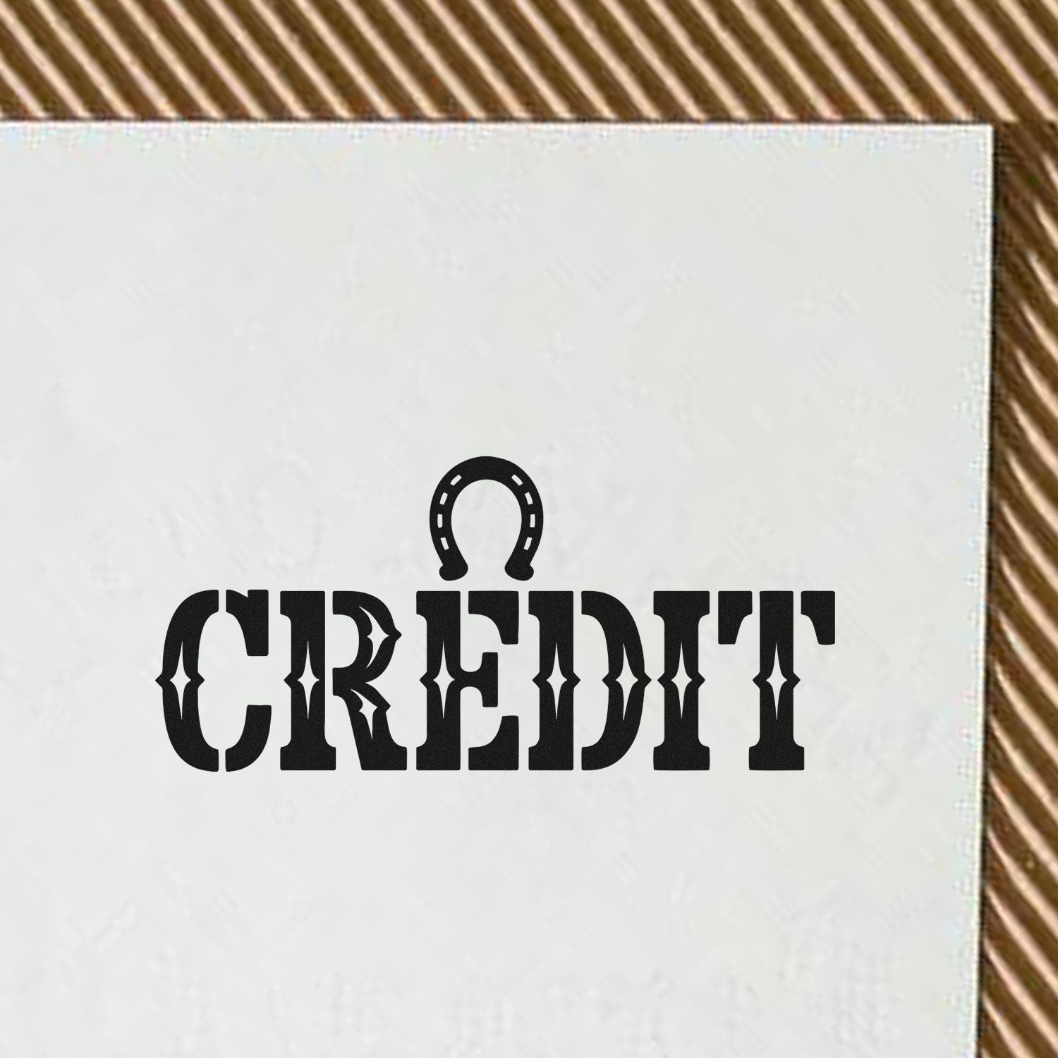 Black CREDIT stamp with horseshoe icon on a white square seal, set against a brown striped background.