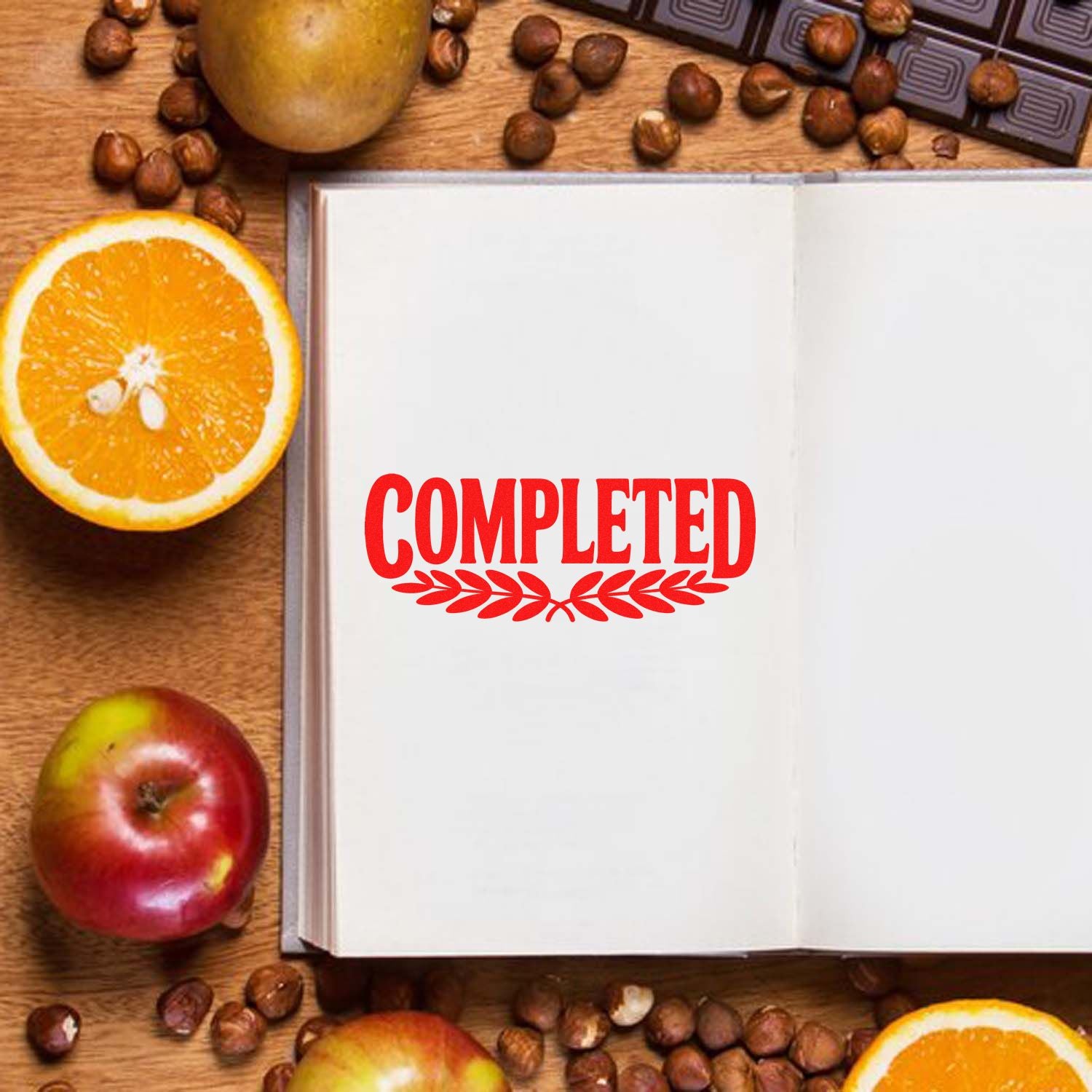 Open notebook with red COMPLETED stamp and leaf seal, surrounded by oranges, apples, and coffee beans.