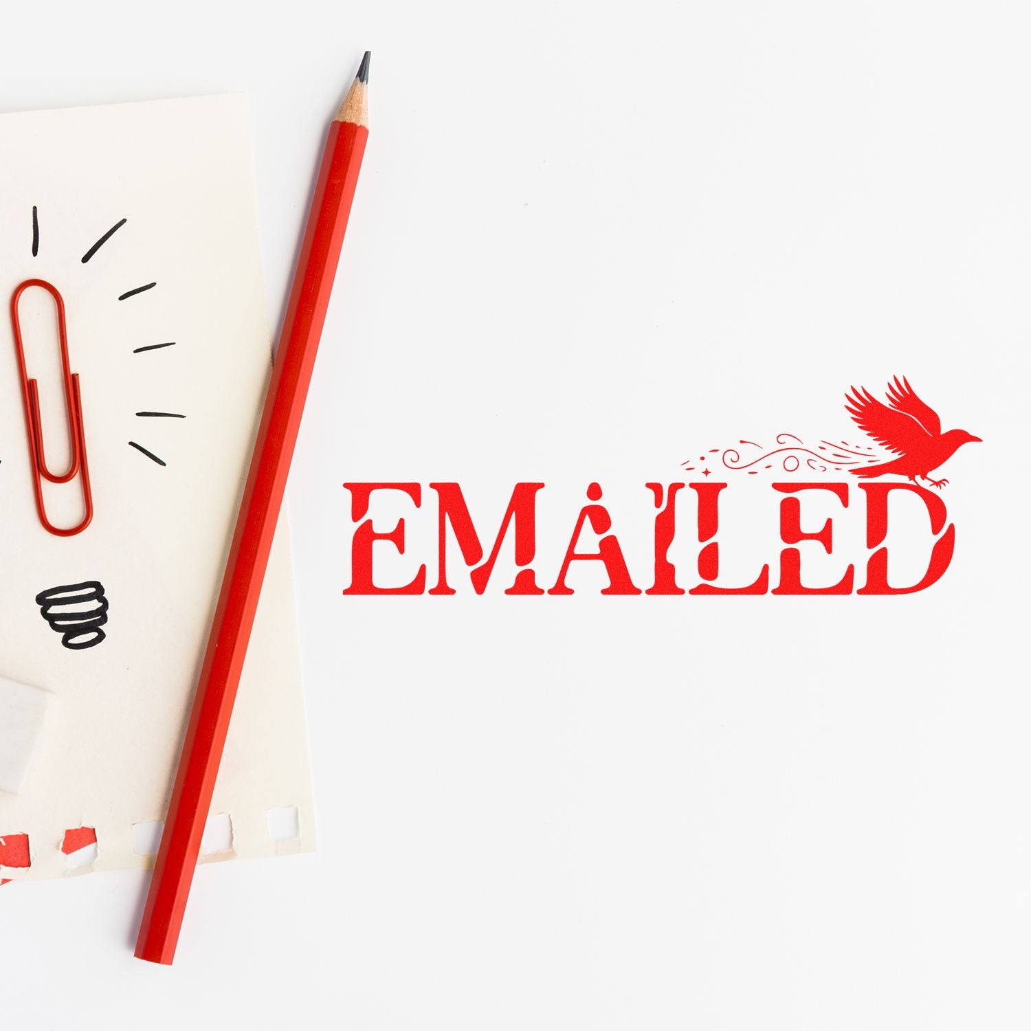 Red EMAILED stamp and bird seal beside a red pencil and paperclip on white paper.