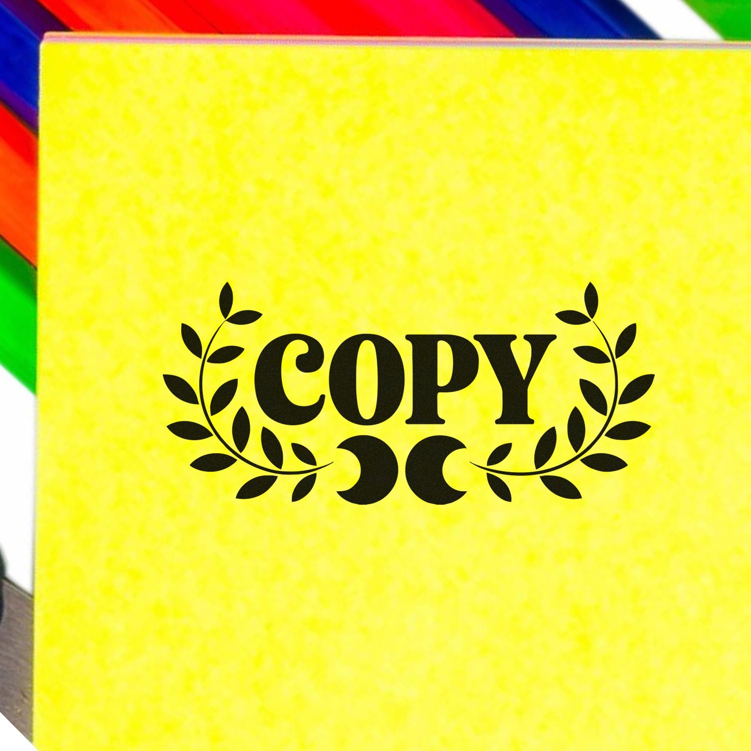 Yellow copy stamp pad with black laurel seal graphic on a colorful rainbow-striped background.