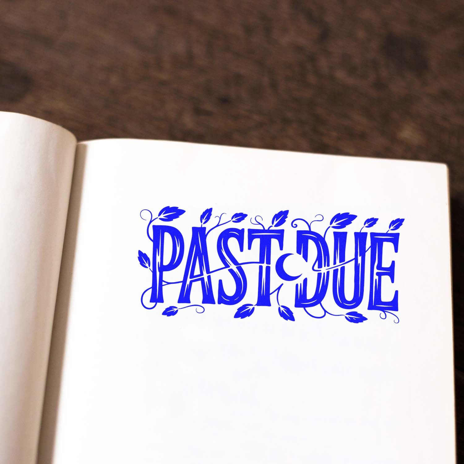Blue decorative PAST DUE stamp seal with leafy accents on a white page