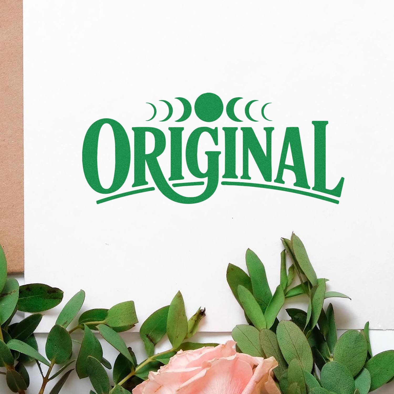Green ORIGINAL stamp and seal design on white card with crescent accents, framed by eucalyptus leaves and a pink rose.
