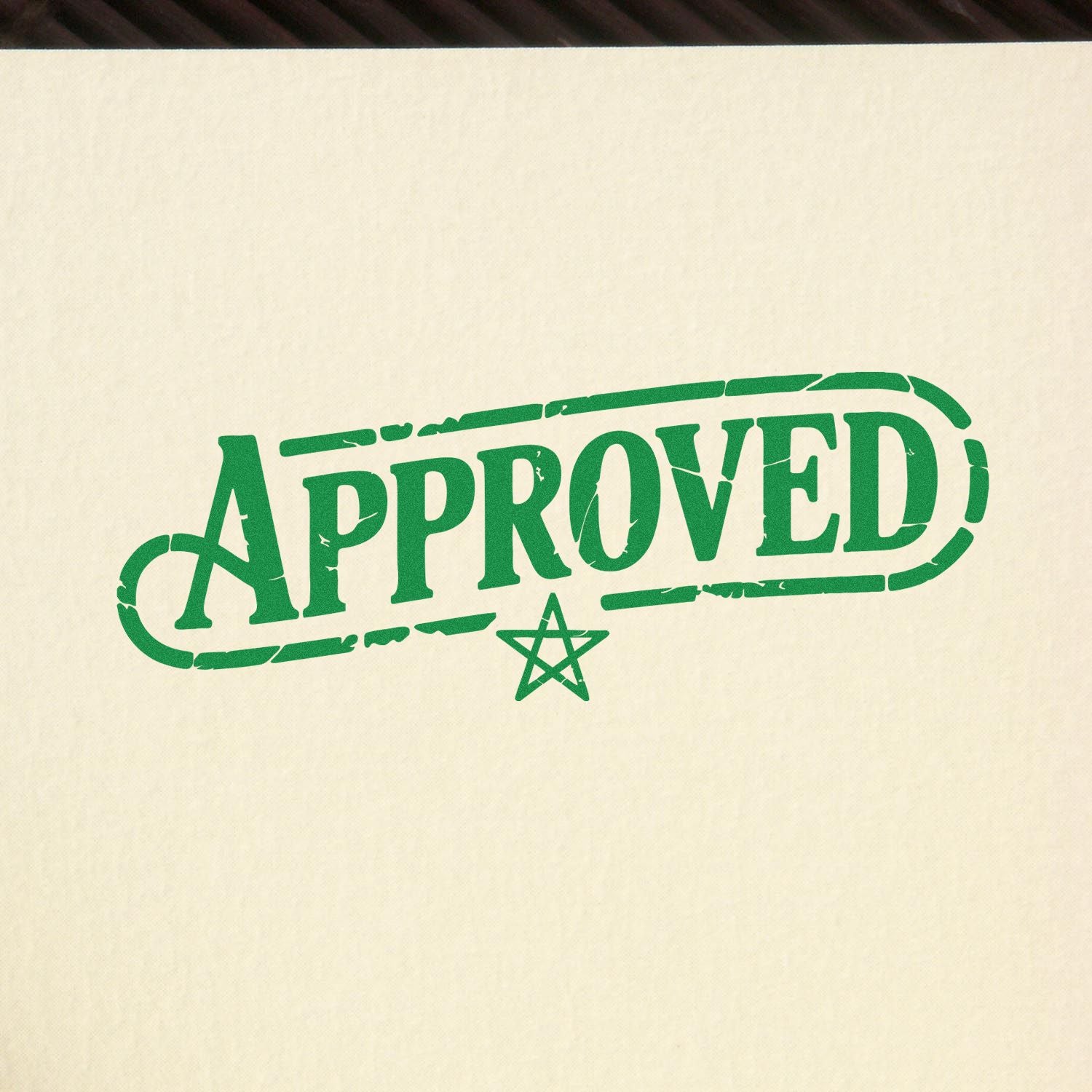 Green APPROVED rubber stamp seal with star on cream background