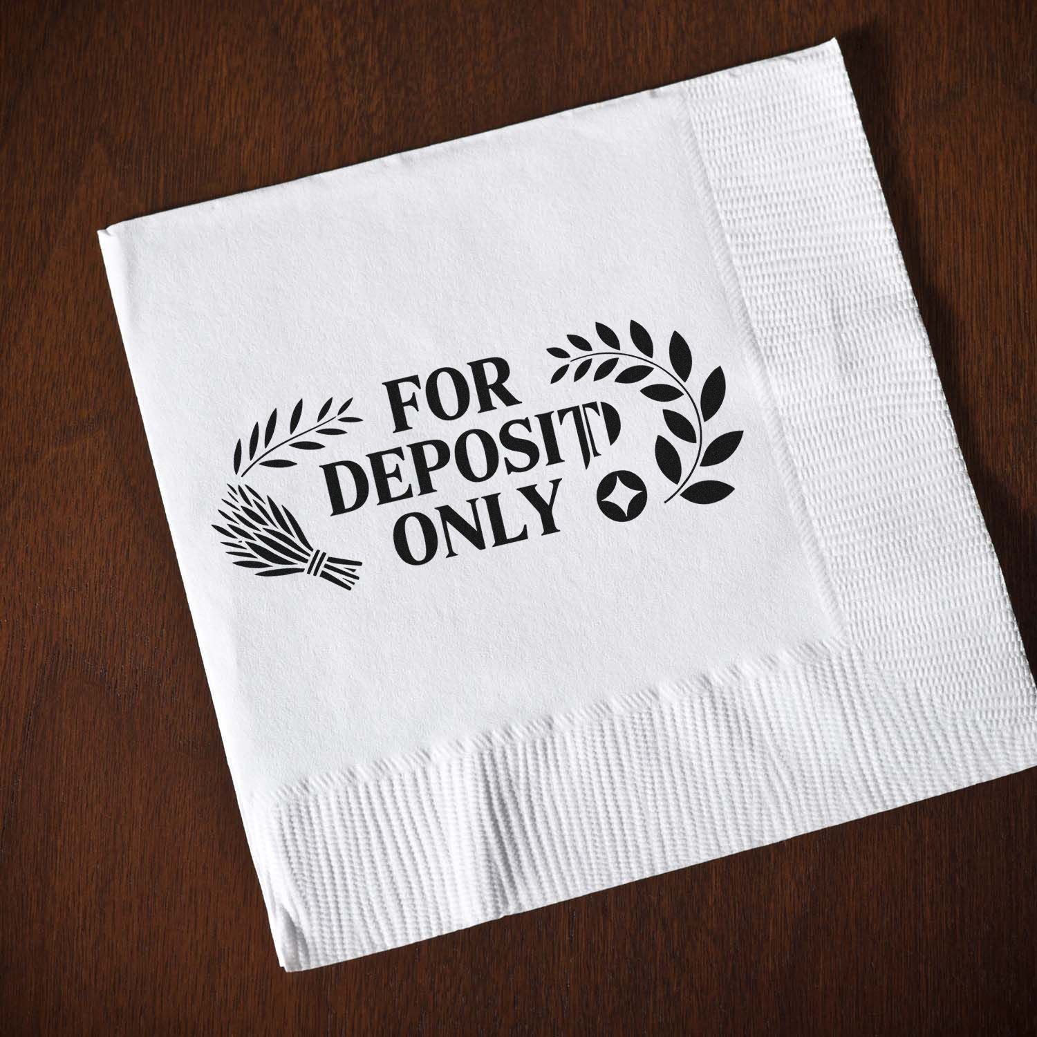 Black For Deposit Only stamp and leaf seal on a white napkin over a brown wood background.