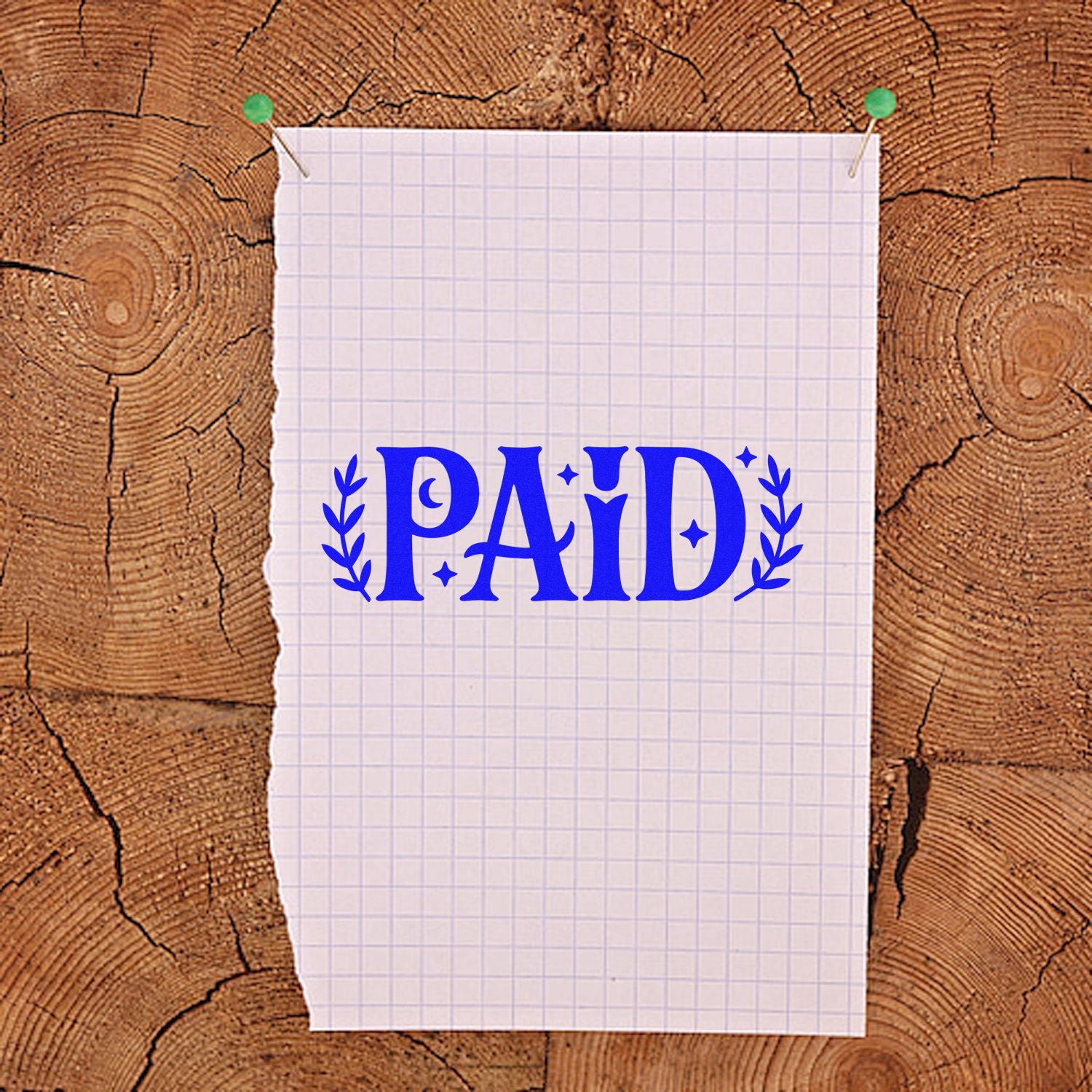 Blue PAID stamp seal on torn graph paper pinned to a wood-grain background.