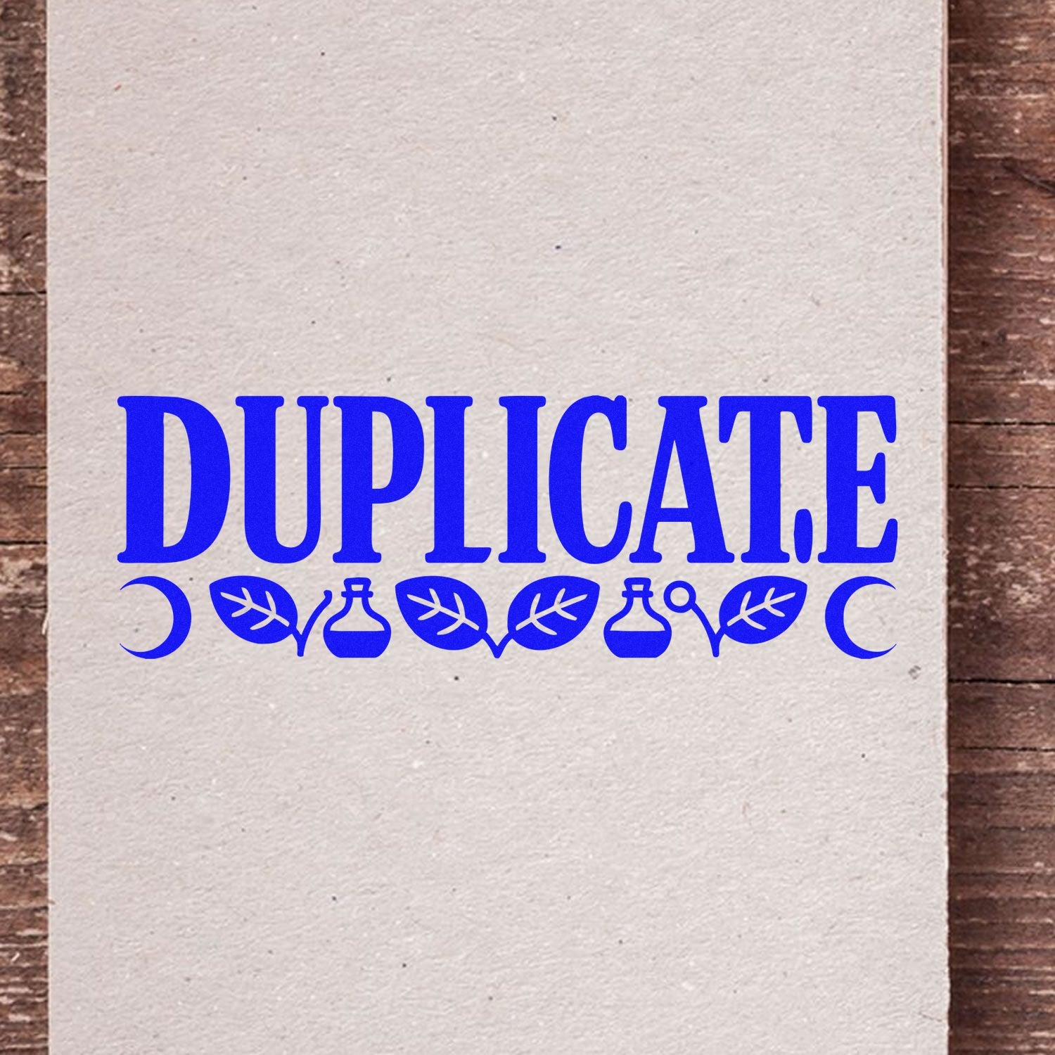 Blue DUPLICATE stamp and seal design with decorative leaves on beige paper, set on a rustic wood background.