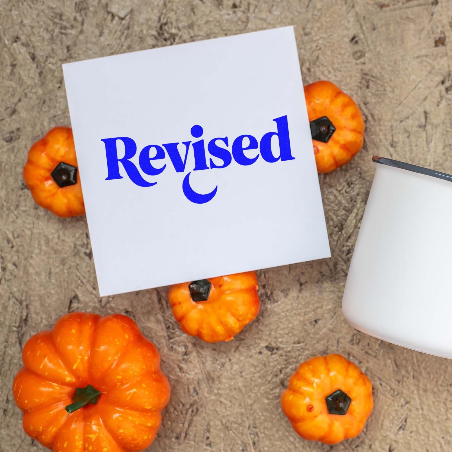 Blue Revised stamp on white card, with orange pumpkins and a white stamp-and-seal product beside it.
