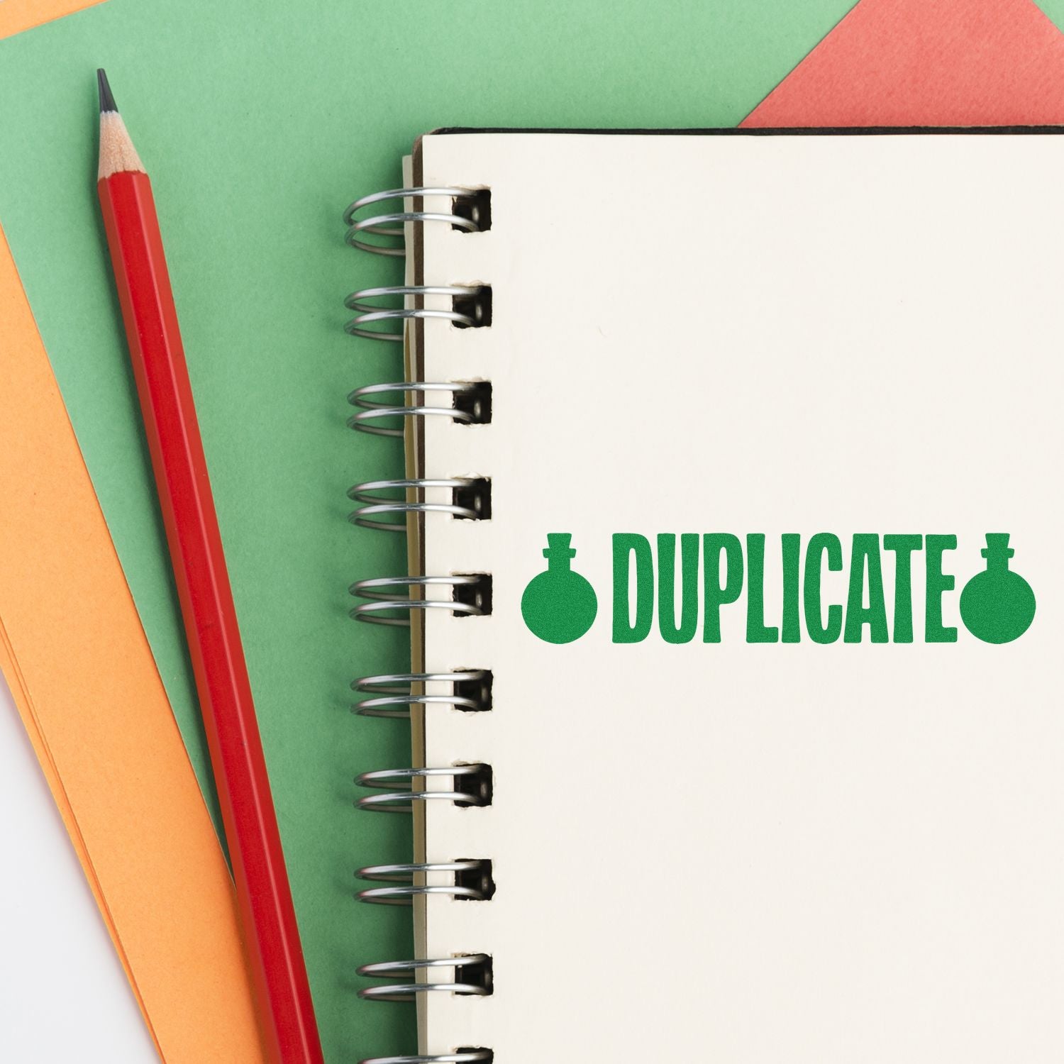 Notebook with green DUPLICATE stamp and seal icons, red pencil, on colorful green, orange and pink paper background.