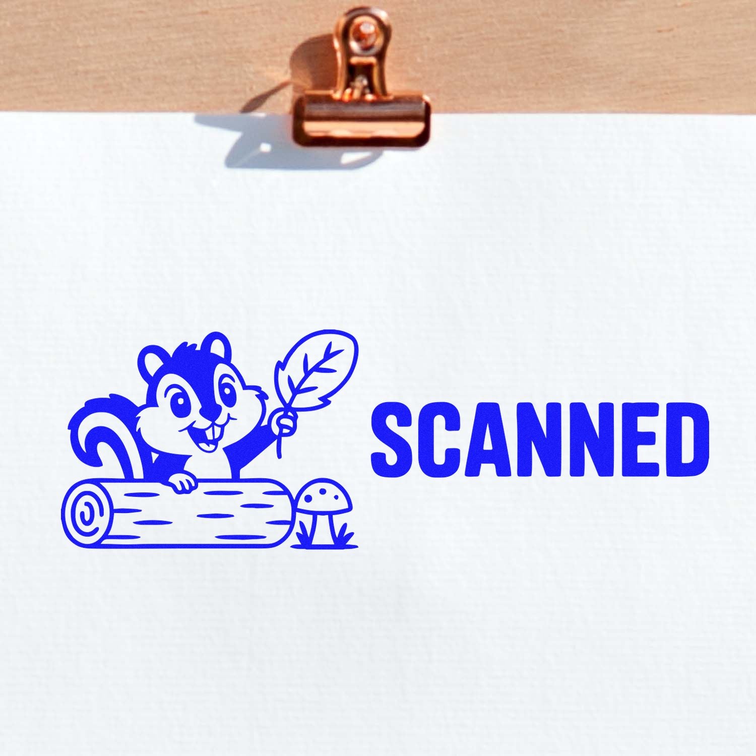 Blue SCANNED stamp with cartoon squirrel and leaf in bold blue on white paper, clipped to a copper clipboard seal.
