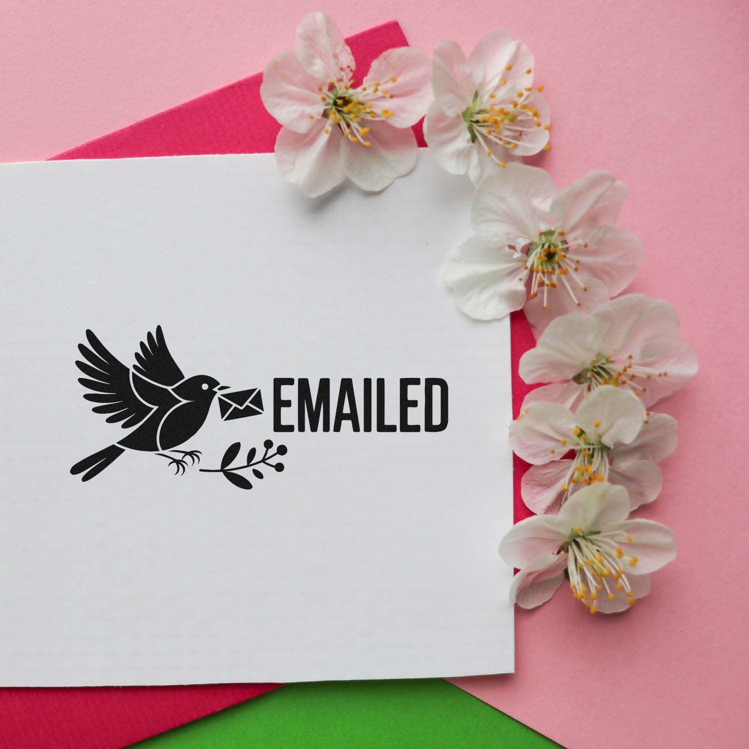 Black EMAILED stamp and seal with bird and envelope on white card, on pink background with white blossoms