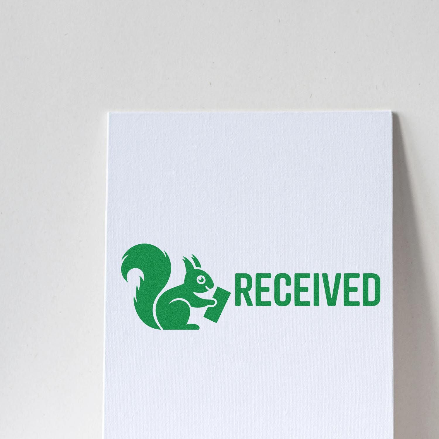 Green squirrel RECEIVED stamp seal in bold green on a white textured card