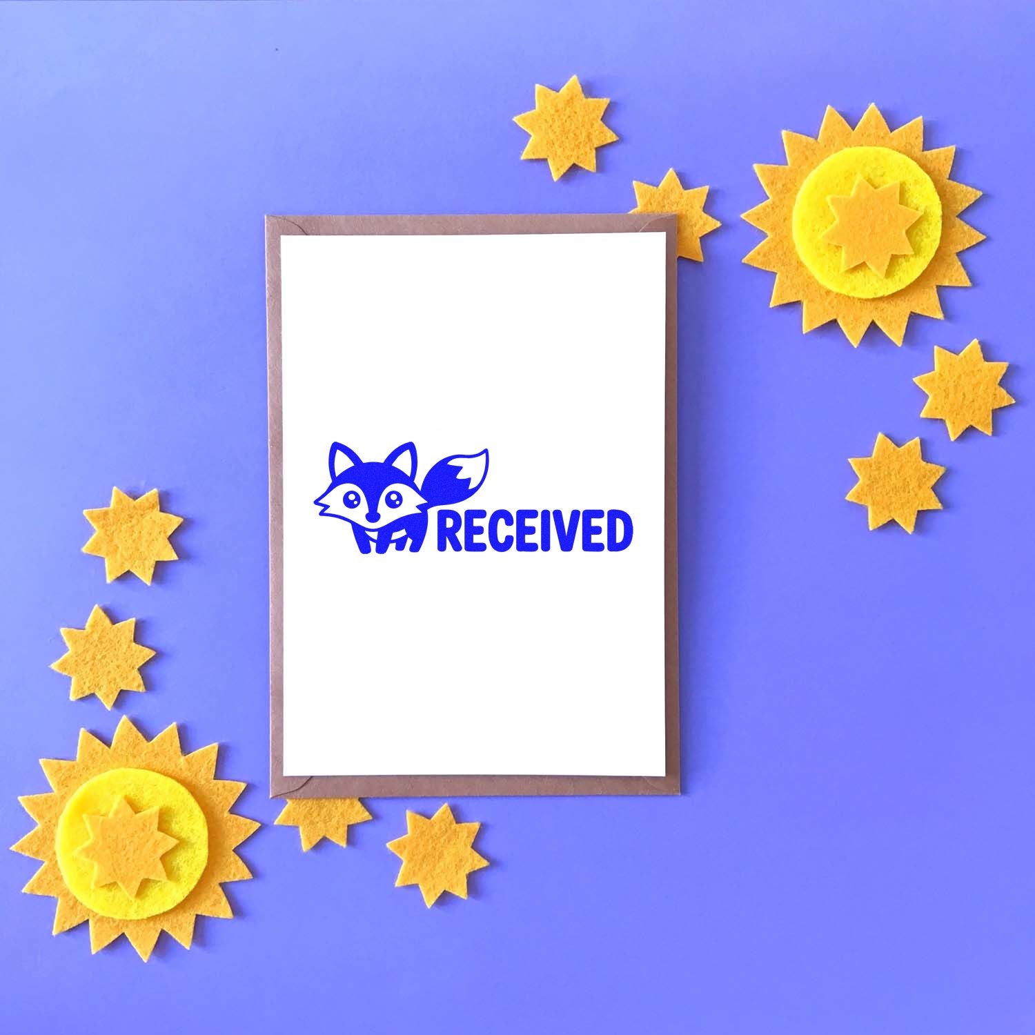 Blue RECEIVED fox stamp with yellow star seal accents on a purple background, shown on a white card.