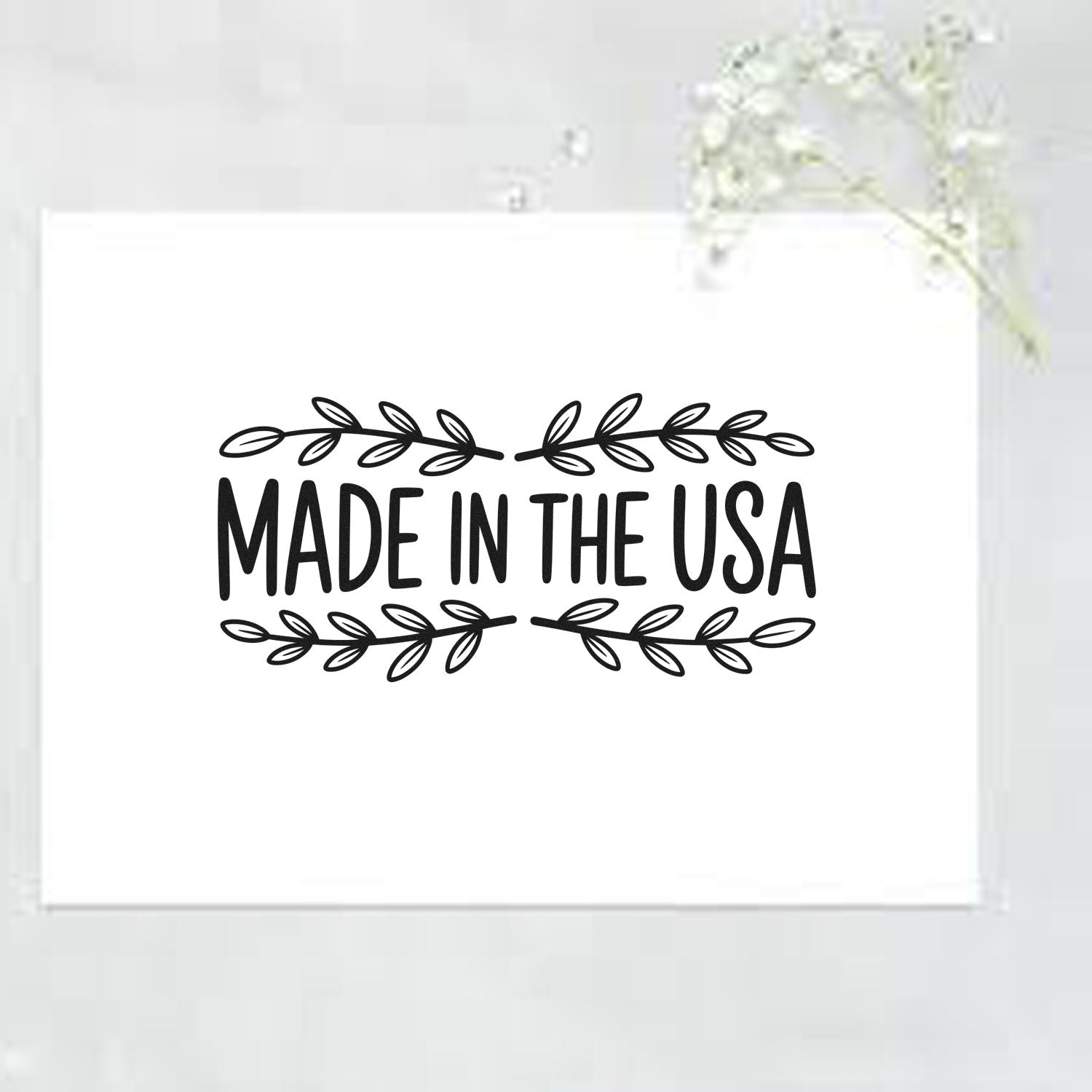 Black Made in the USA stamp with leafy border on a white seal.