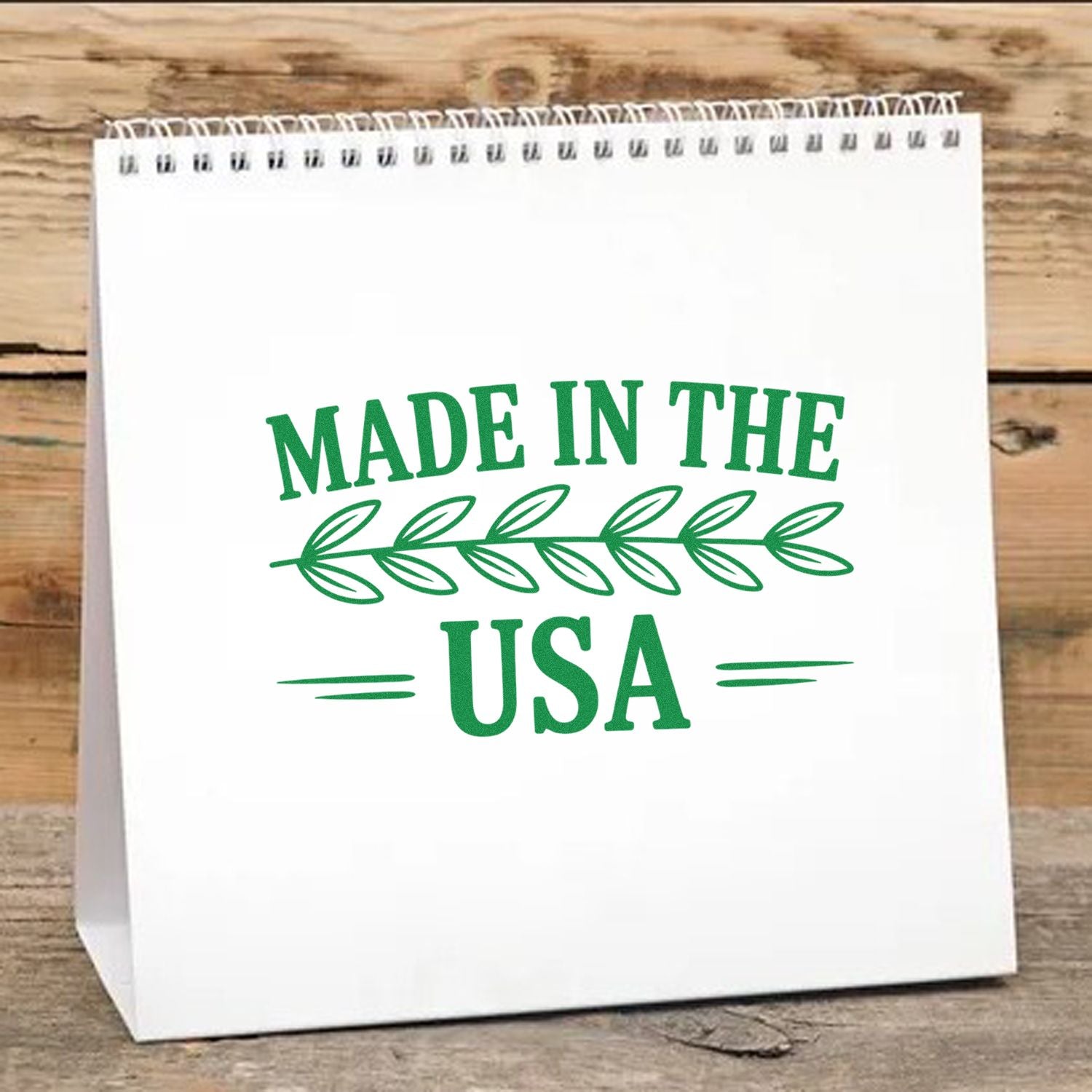 Green Made in the USA stamp and seal design with leaf motif on a white paper bag.