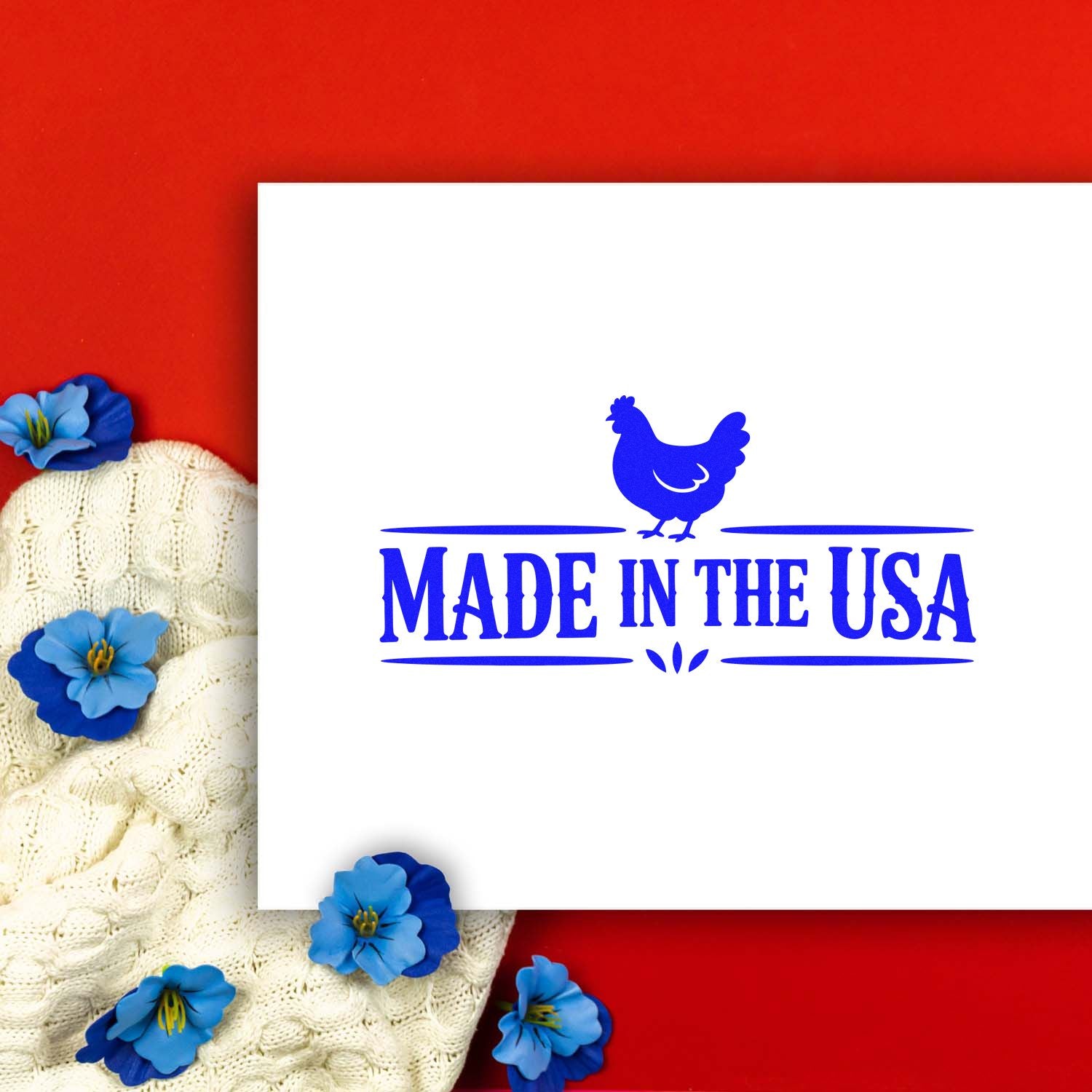 Blue Made in the USA stamp with chicken icon on white card, set on red background with cream knit and blue flowers.