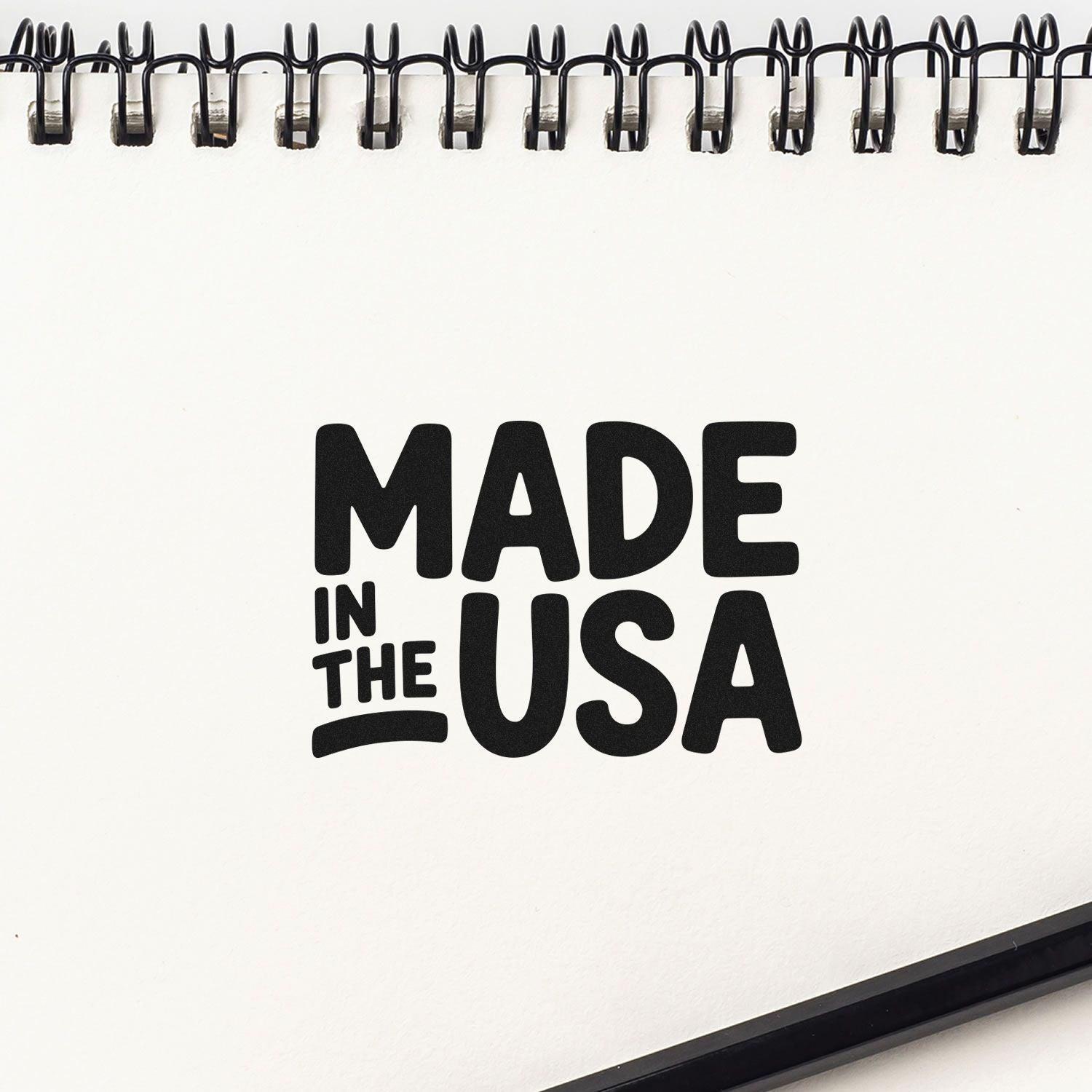 Black Made in the USA seal-style stamp on a white spiral notebook page with bold black lettering.