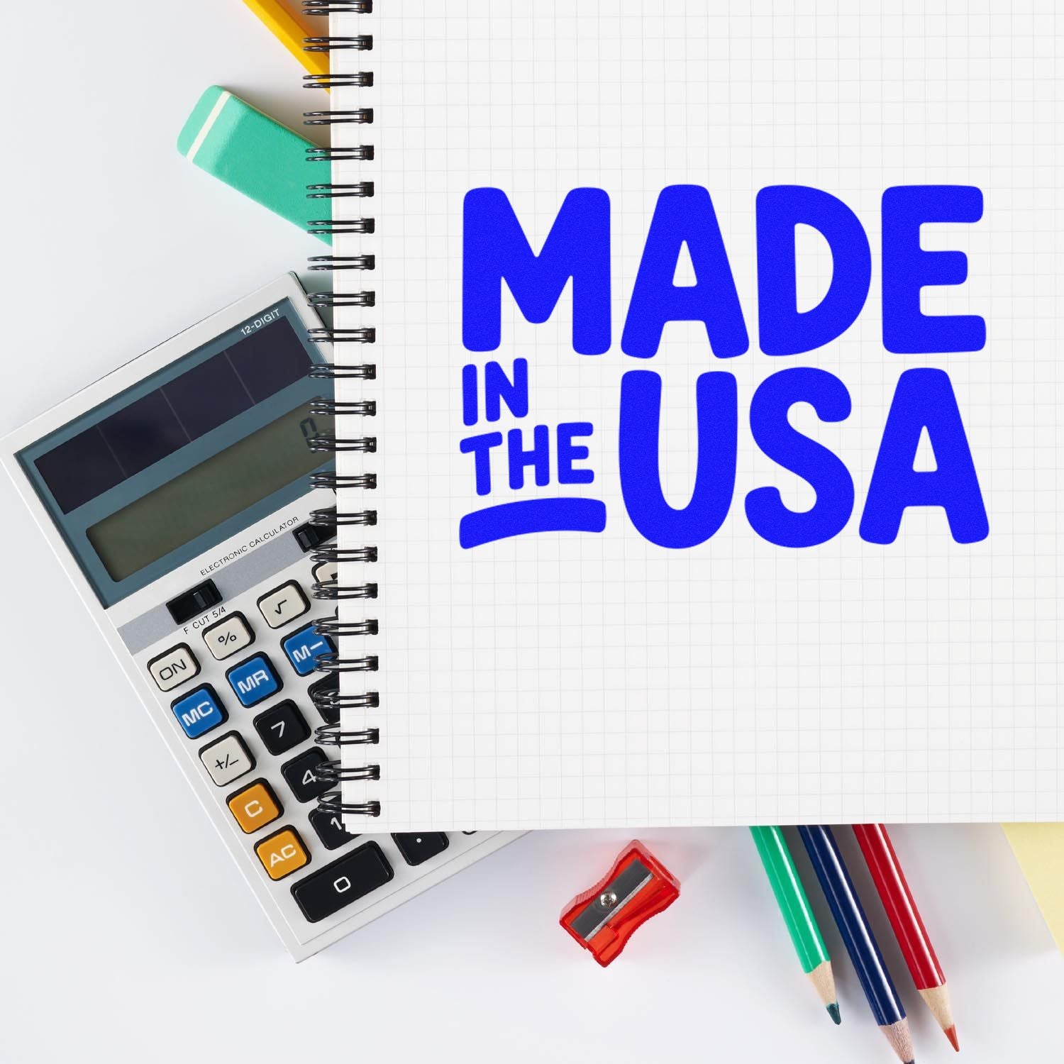 Made in the USA stamp and seal set with blue lettering, calculator, spiral notebook, pencils, and red sharpener.