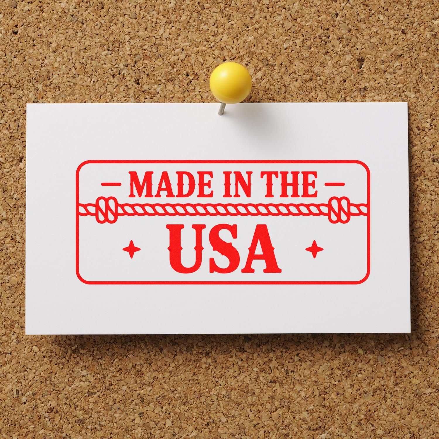 Red Made in the USA stamp seal on white card, pinned to corkboard with a yellow pushpin.