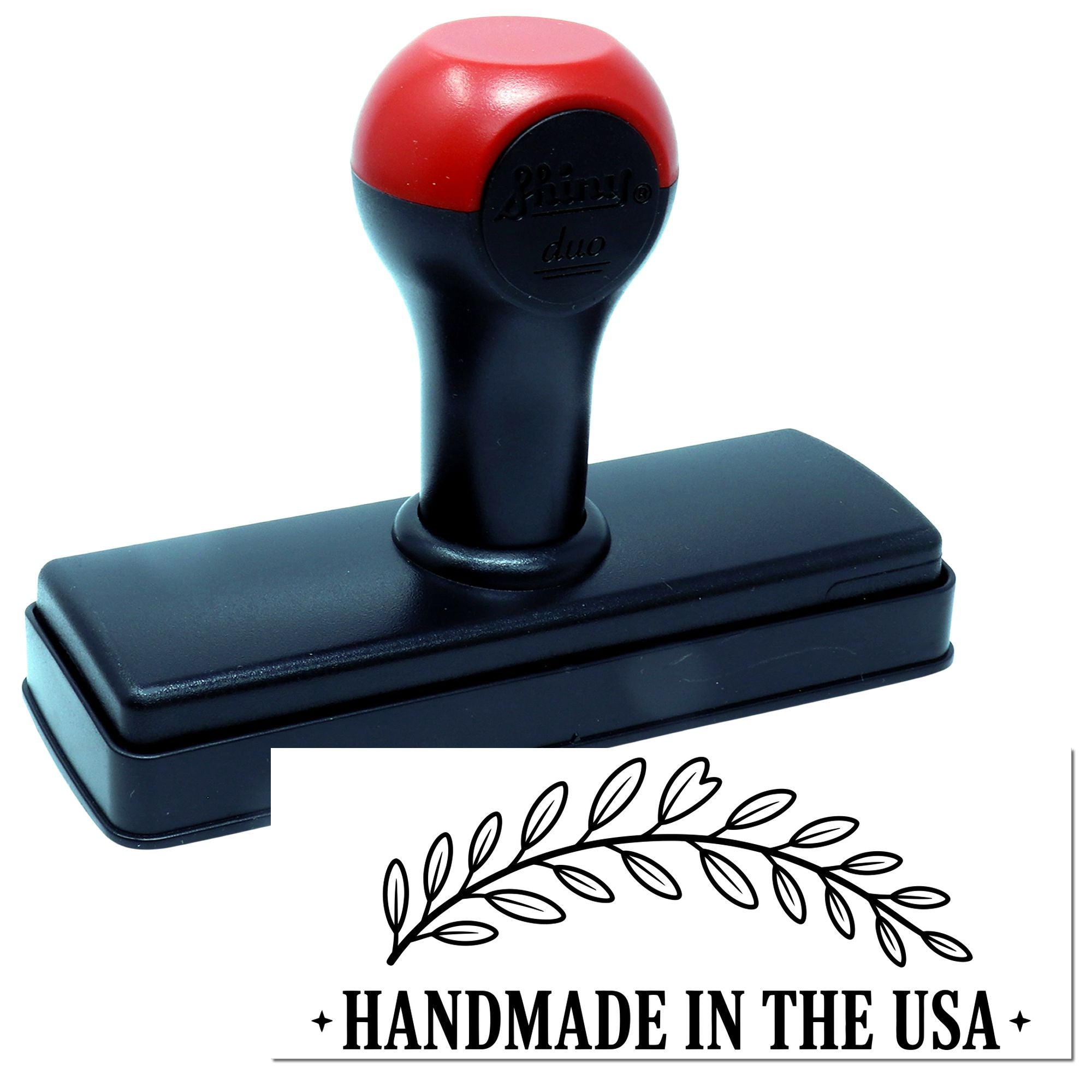 Red and black self-inking stamp with rectangular base, showing a laurel seal and HANDMADE IN THE USA imprint.