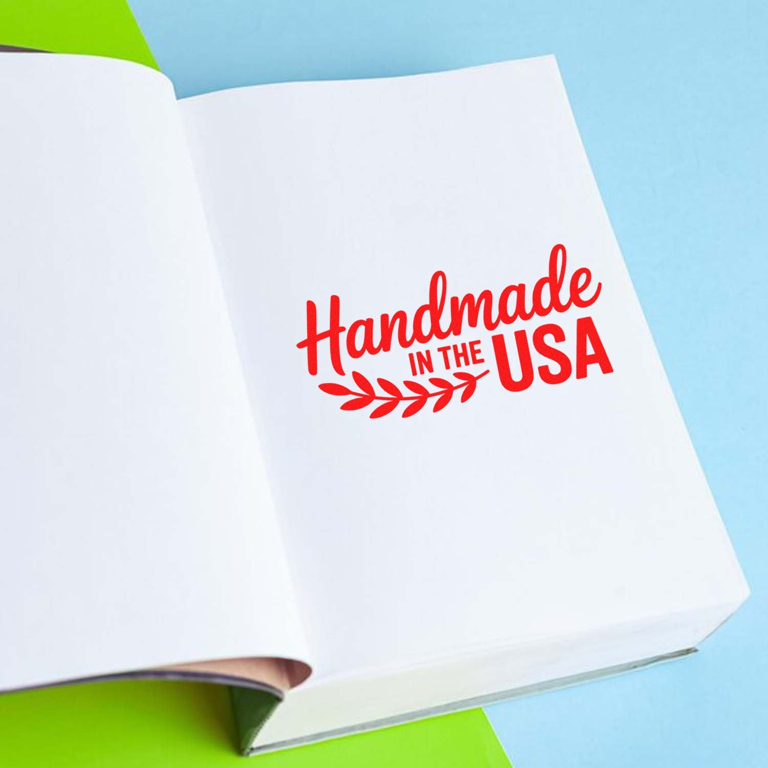 Red Handmade in the USA stamp with leaf seal on white paper, against a blue and green background.